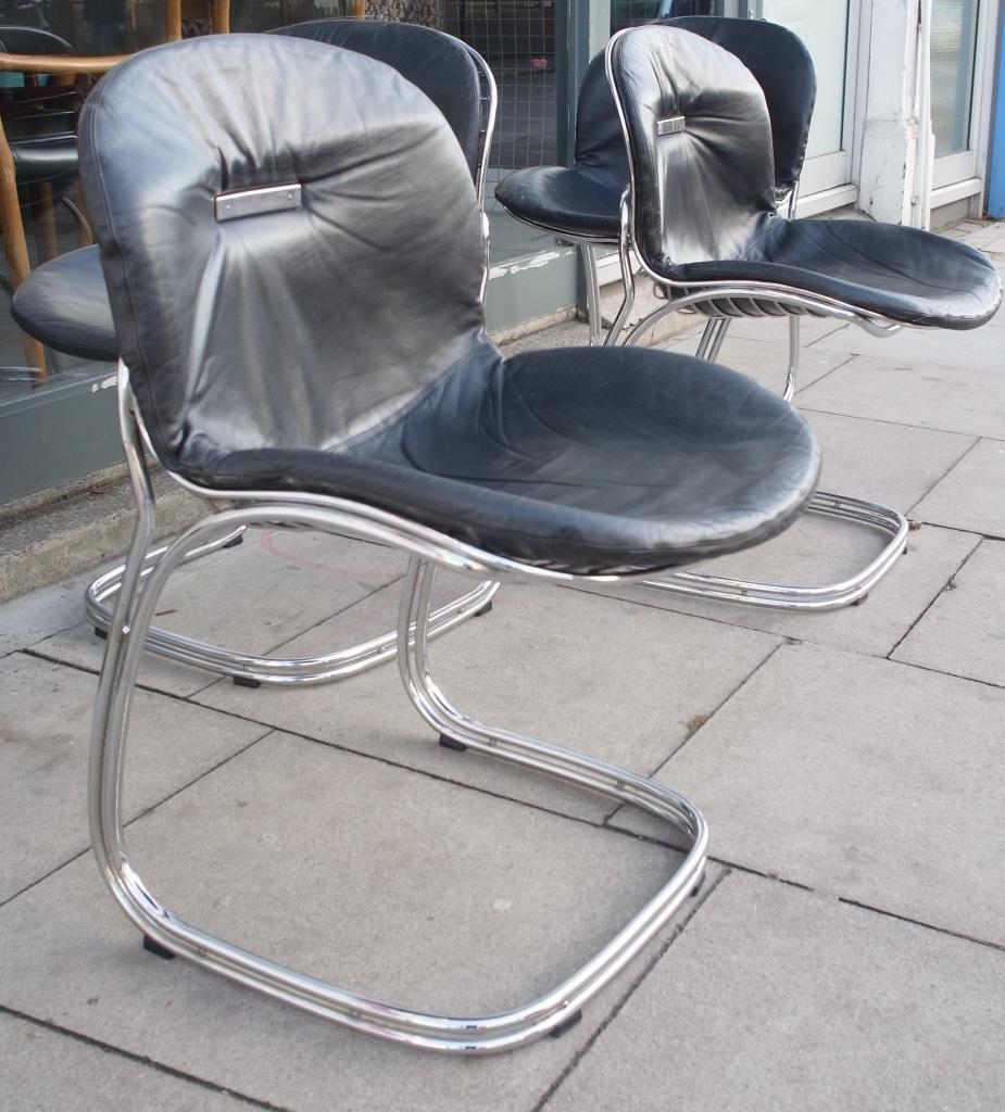 A very stylish and rare set of four 1970s, Italian chrome framed, cantilevered dining chairs, with a black leather back/seat cushion. Designed by Gastone Rinaldi for Rima.

These 'Sabrina' chairs are in very good vintage condition, the leather,
