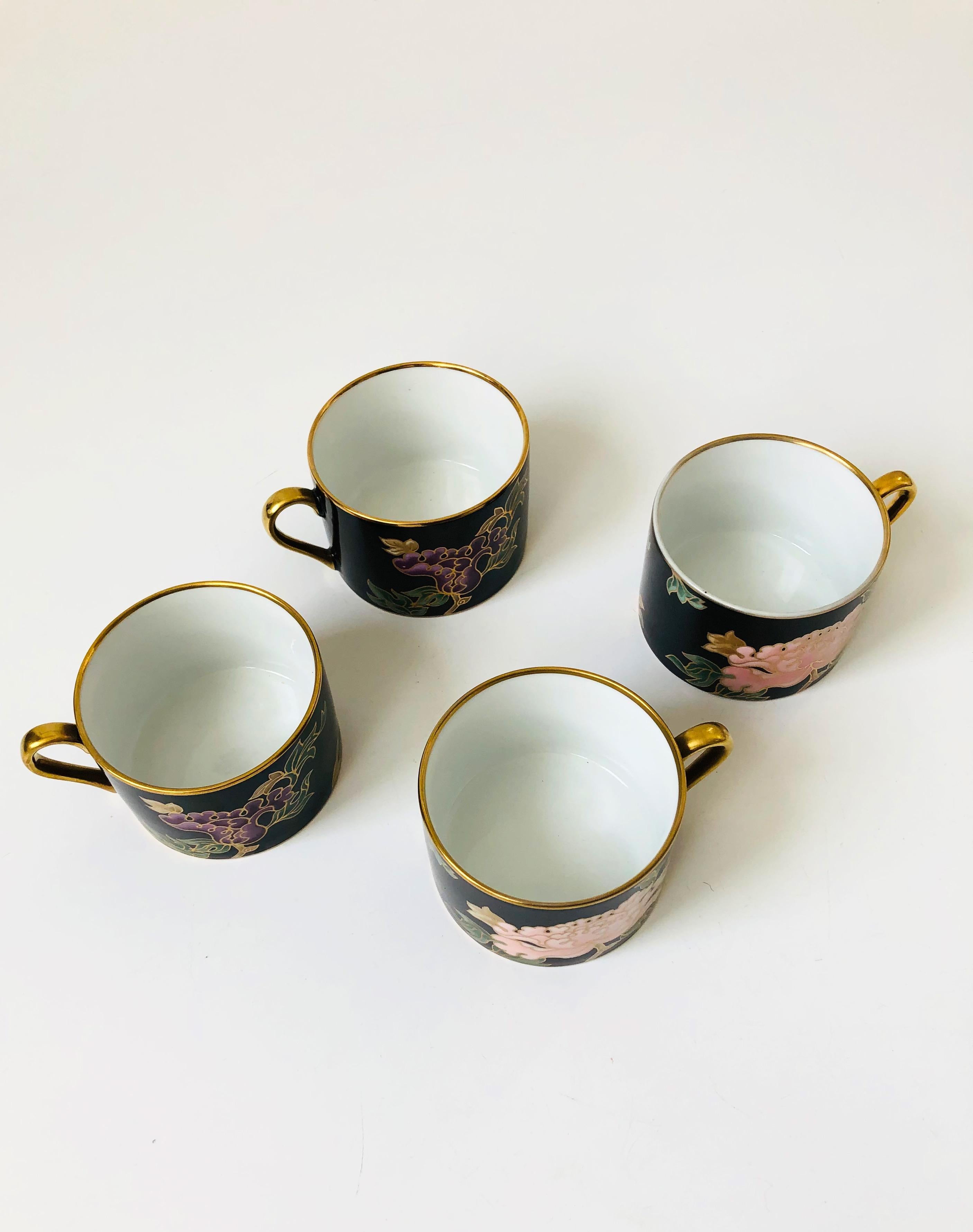 A set of vintage 1970s ceramic mugs by Fitz and Floyd. Beautiful floral design in purple, pink, and gold over a black base color in the 