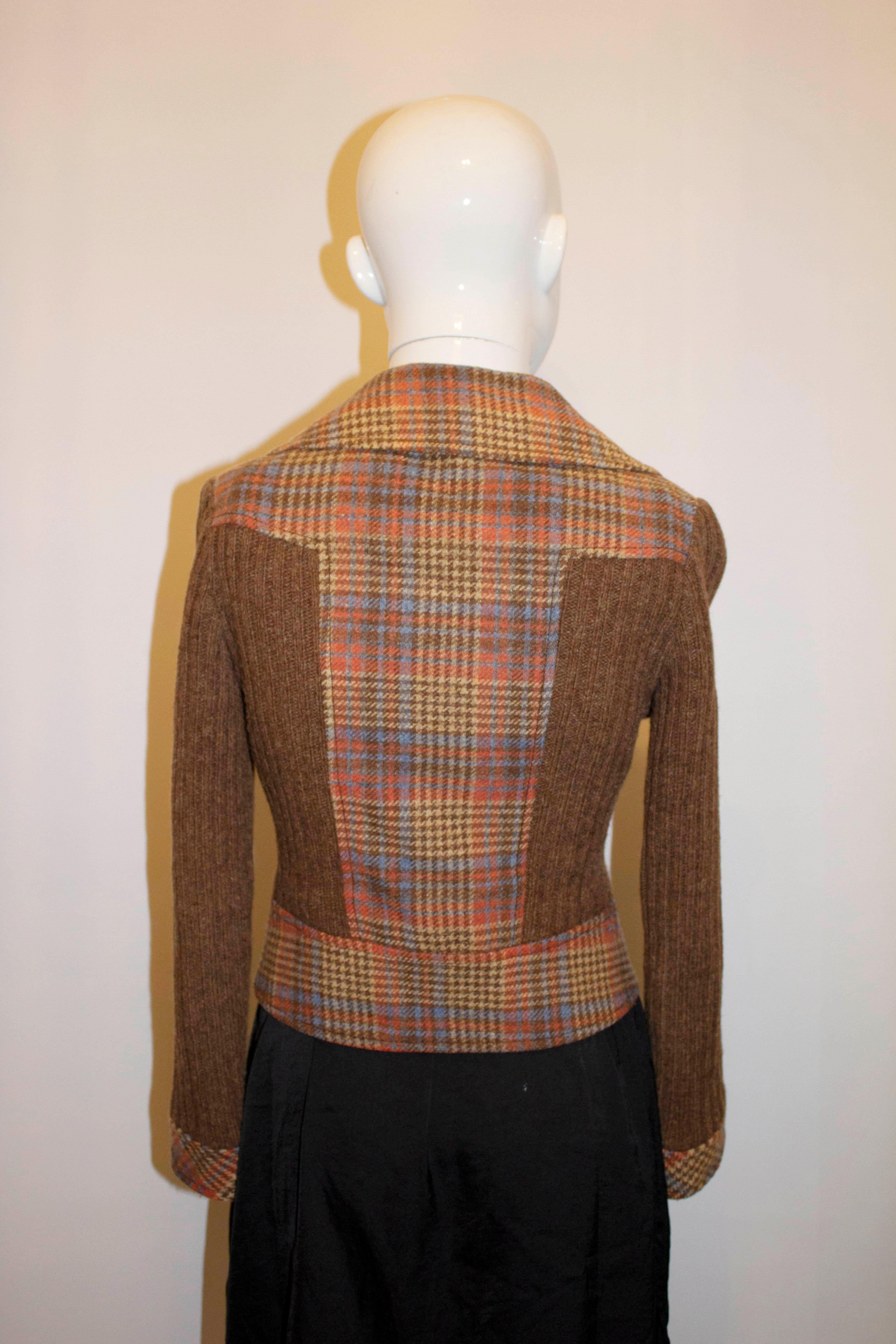 A fun vintage jacket from the 1970s. The wool jacket has a cut away collar, is double breasted with two columns of four buttons. The fabric is in a mix of red, yellow and brown check with knitted detail on the front, sleaves and part of the