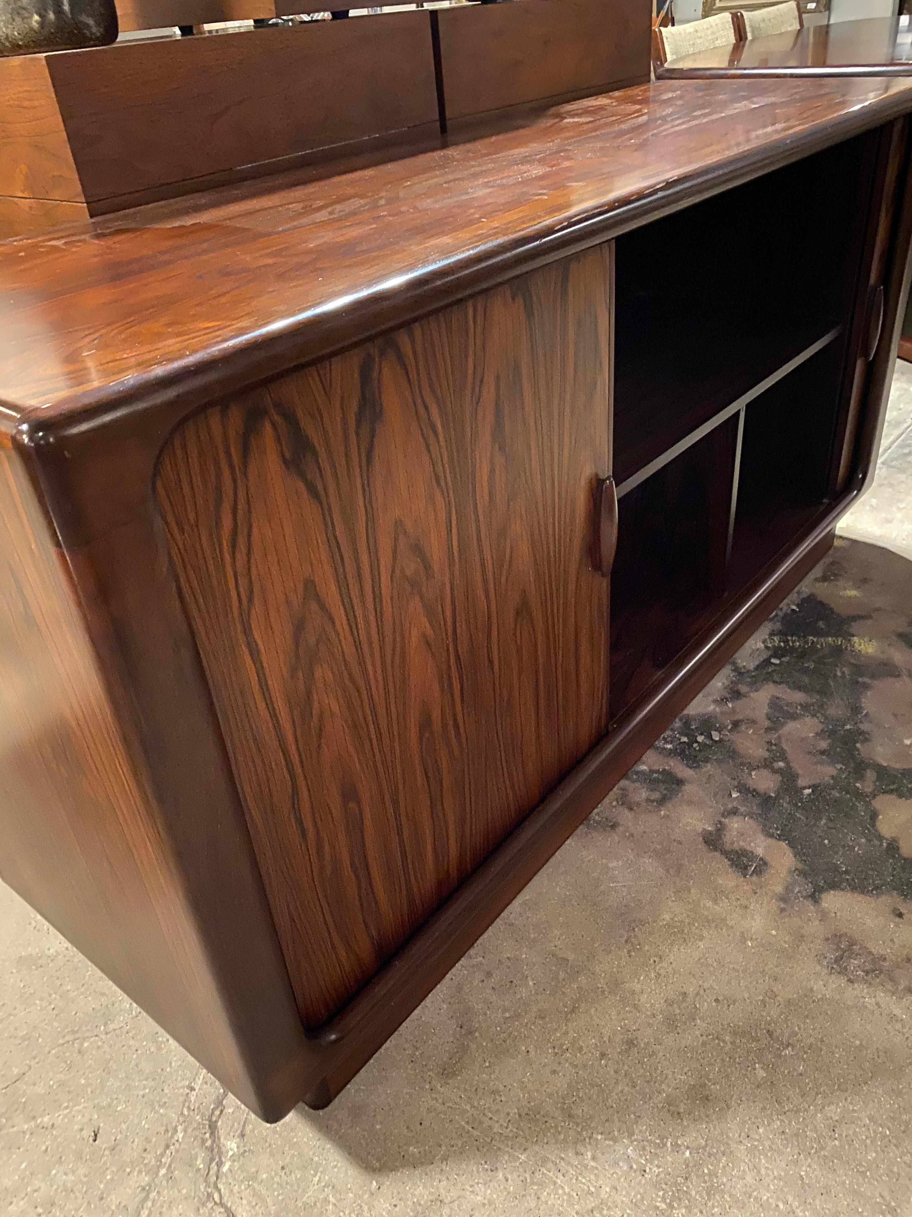 This vintage Danish modern rosewood credenza by Dyrlund is in very good condition overall. Features smooth sliding tambour doors. Plinth base. Interior drawers and shelves for storage.
Denmark, circa 1970s.
Dimensions:
51.5
