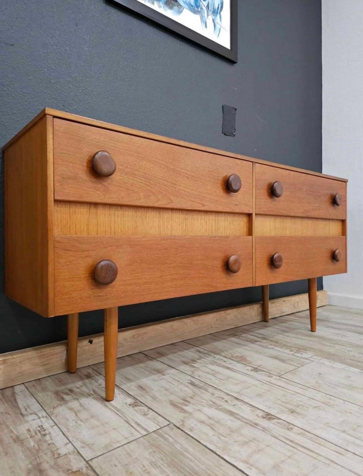 uper clean, mint condition four drawer danish dresser with mcm style peg legs! Everything is perfect on this piece. Show stopping large knobs give this piece it’s unique flare. Featuring four pullout drawers. Could be used as a dresser or stunning