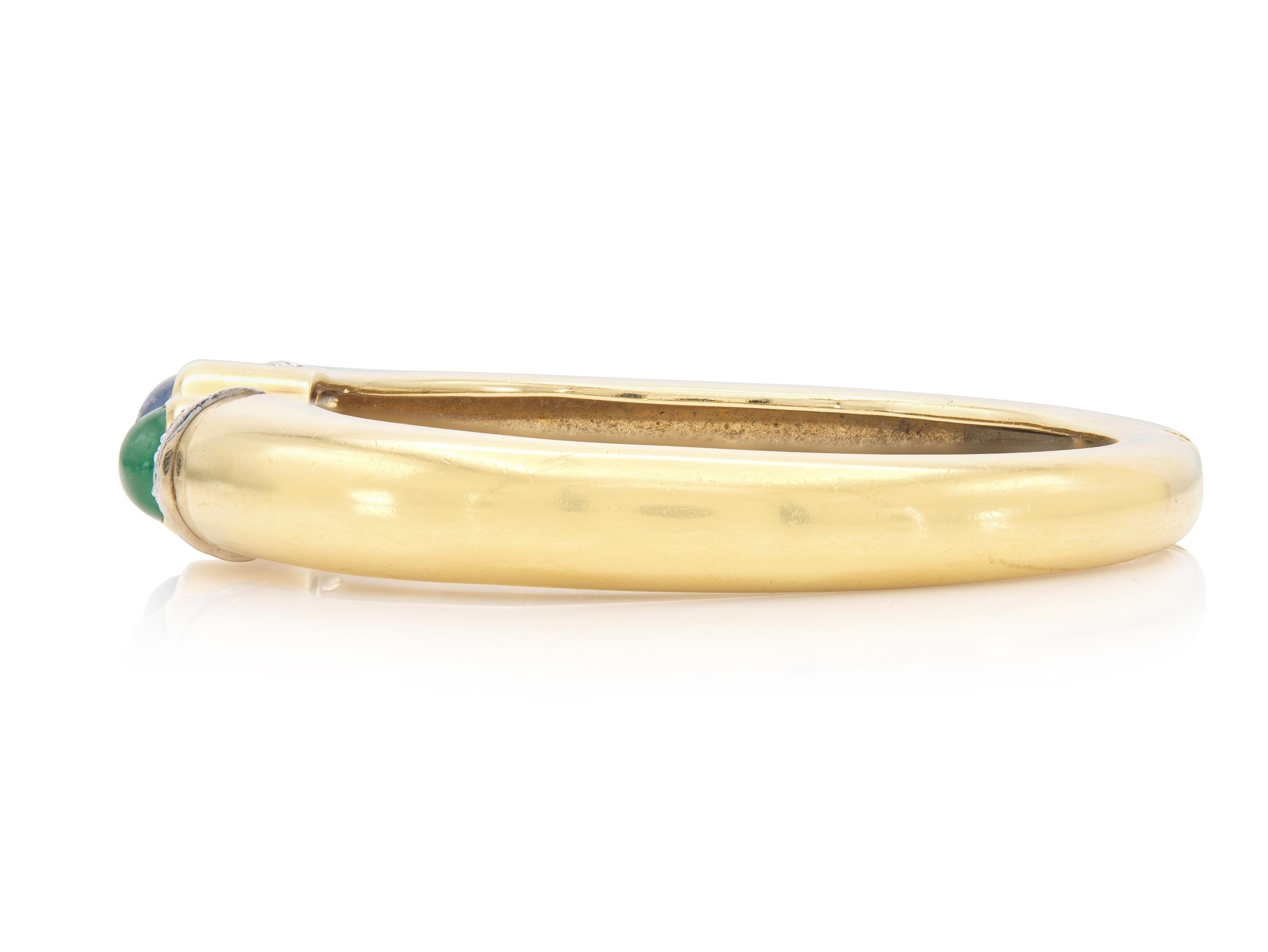 Finely crafted in 18k yellow gold and platinum with a Cabochon Sapphire weighing approximately 3.00 carats, a Cabochon Emerald weighing approximately 2.00 carats, and small Round Brilliant cut Diamonds weighing approximately a total of 0.50