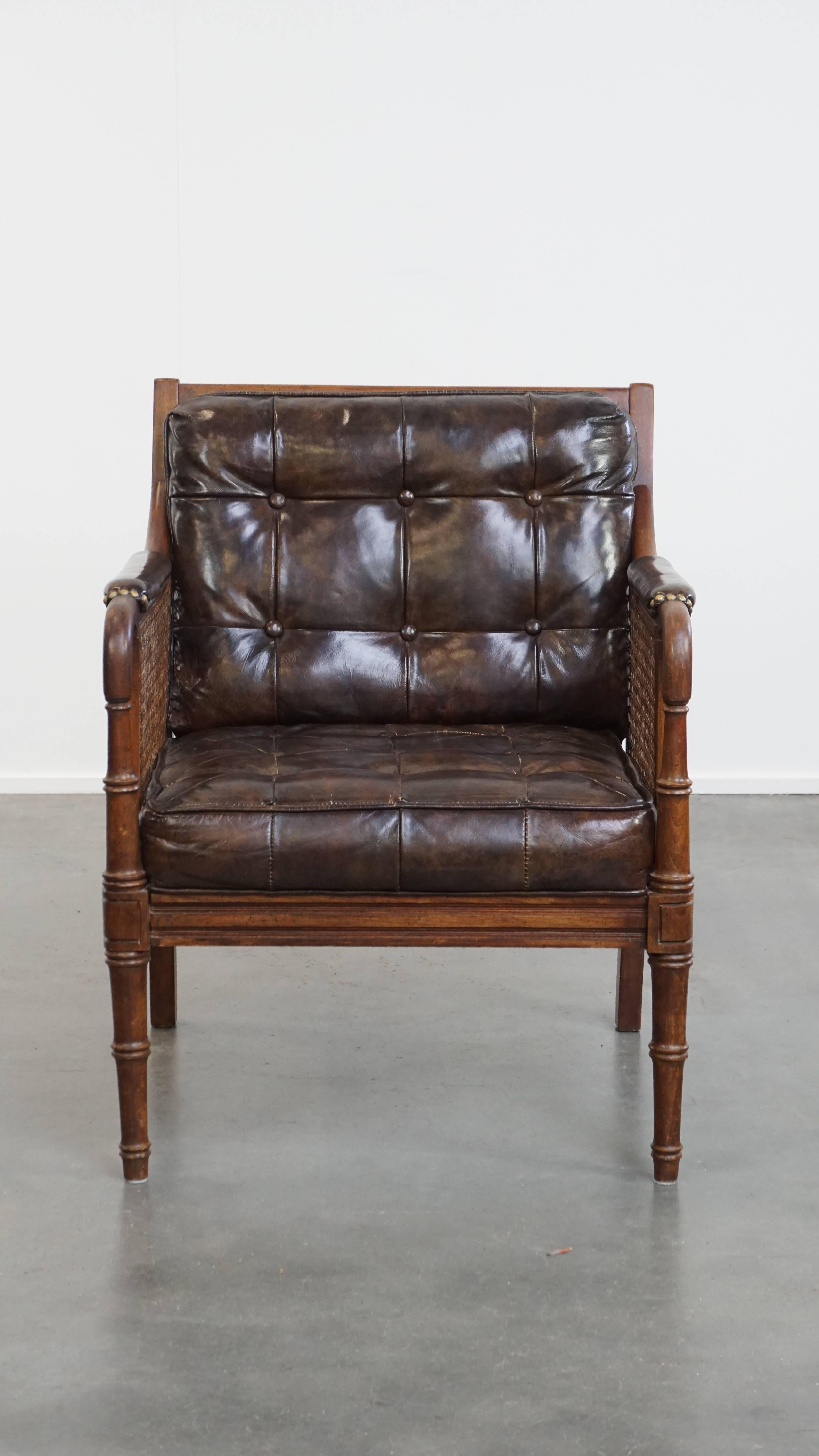 Offered here is this stylish vintage 1970s design armchair made of wood, leather, and webbing. 

Thanks to its materials, this stunning armchair is a real eye-catcher. The combination of wood, leather, and webbing gives it a unique and warm