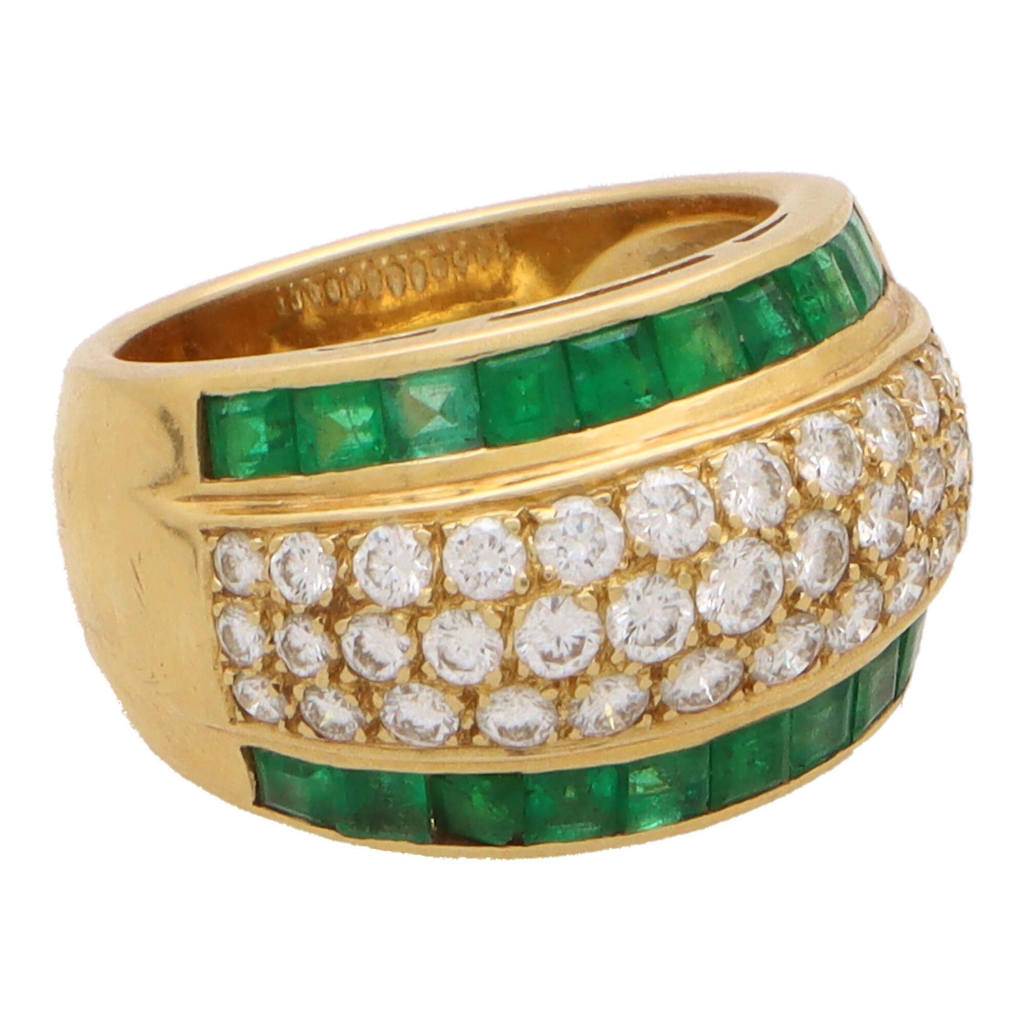  A beautiful vintage 1970's emerald and diamond bombe ring set in 18k yellow gold.

The ring is composed in an iconic 70's bombe design, set centrally with a pave set diamond panel and bordered to each side with calibre cut emeralds. The design is