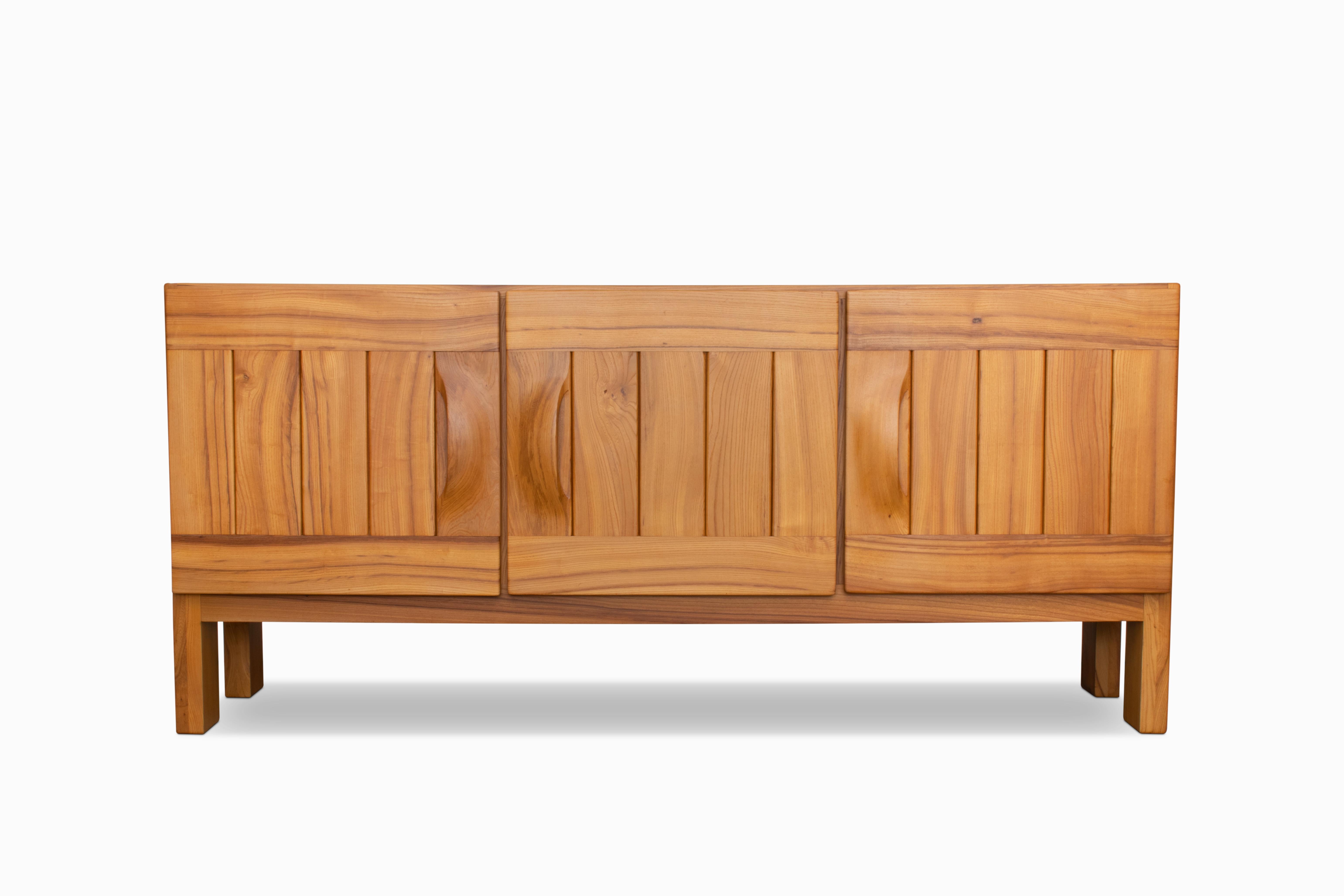 Hier ist ein charmantes französisches Sideboard/Schrank von Maison Regain, ca. 1970er Jahre. Die Konstruktion aus massivem Ulmenholz zeichnet sich durch robuste Schwalbenschwanzverbindungen, geschwungene Griffe und kräftige Beine aus.  Zwei Türen