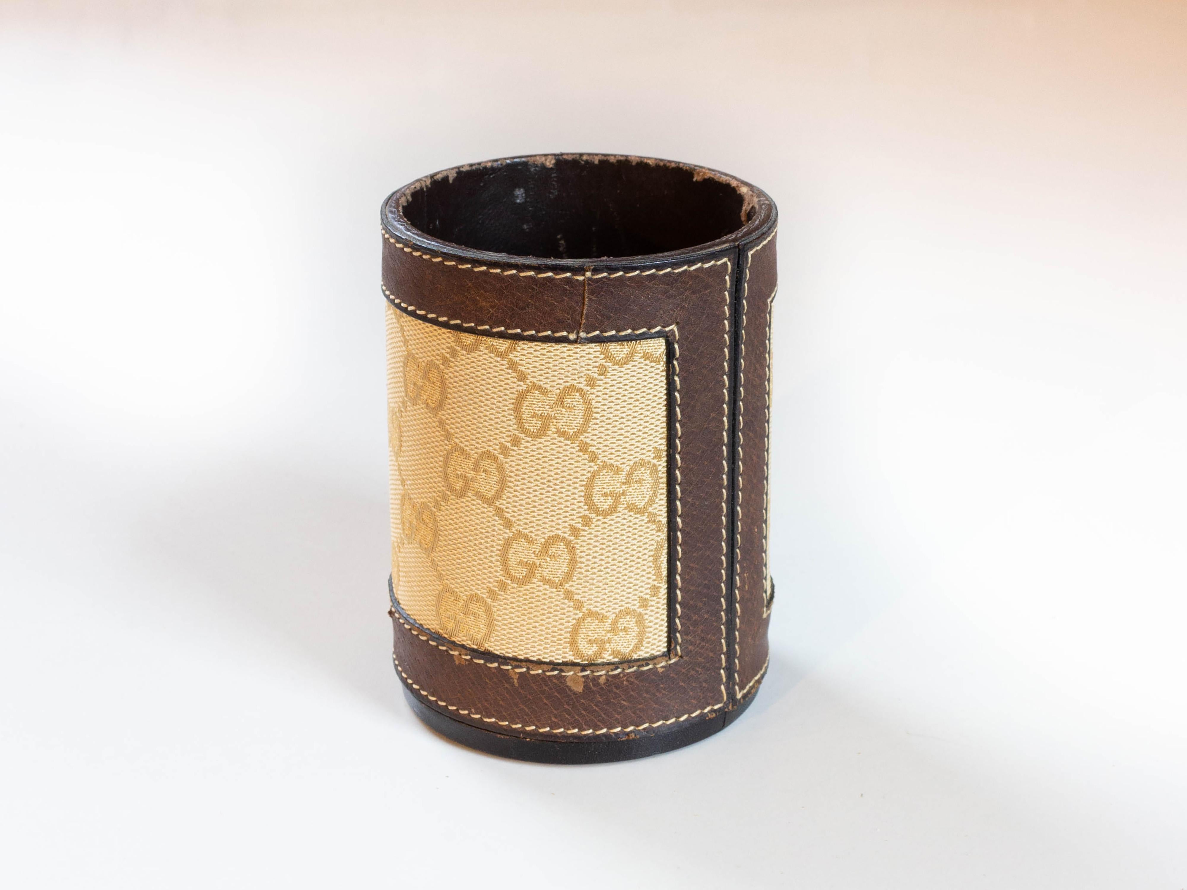 Vintage 1970s Gucci pencil cup holder with gold GG logo canvas and brown leather trim.