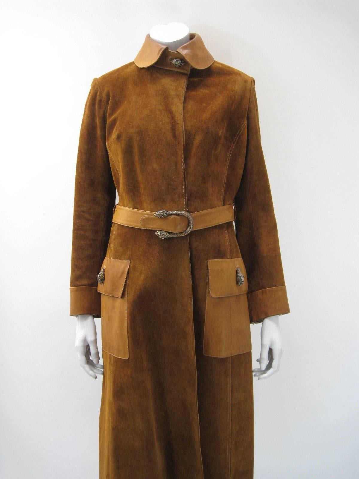 Vintage Gucci warm tan suede trench coat.

Heavier weight suede with sturdy leather trim and pockets.

Hidden button closure.

Self belted with double tiger belt buckle.

Painted metal tiger head hardware throughout.

Back slit with leather