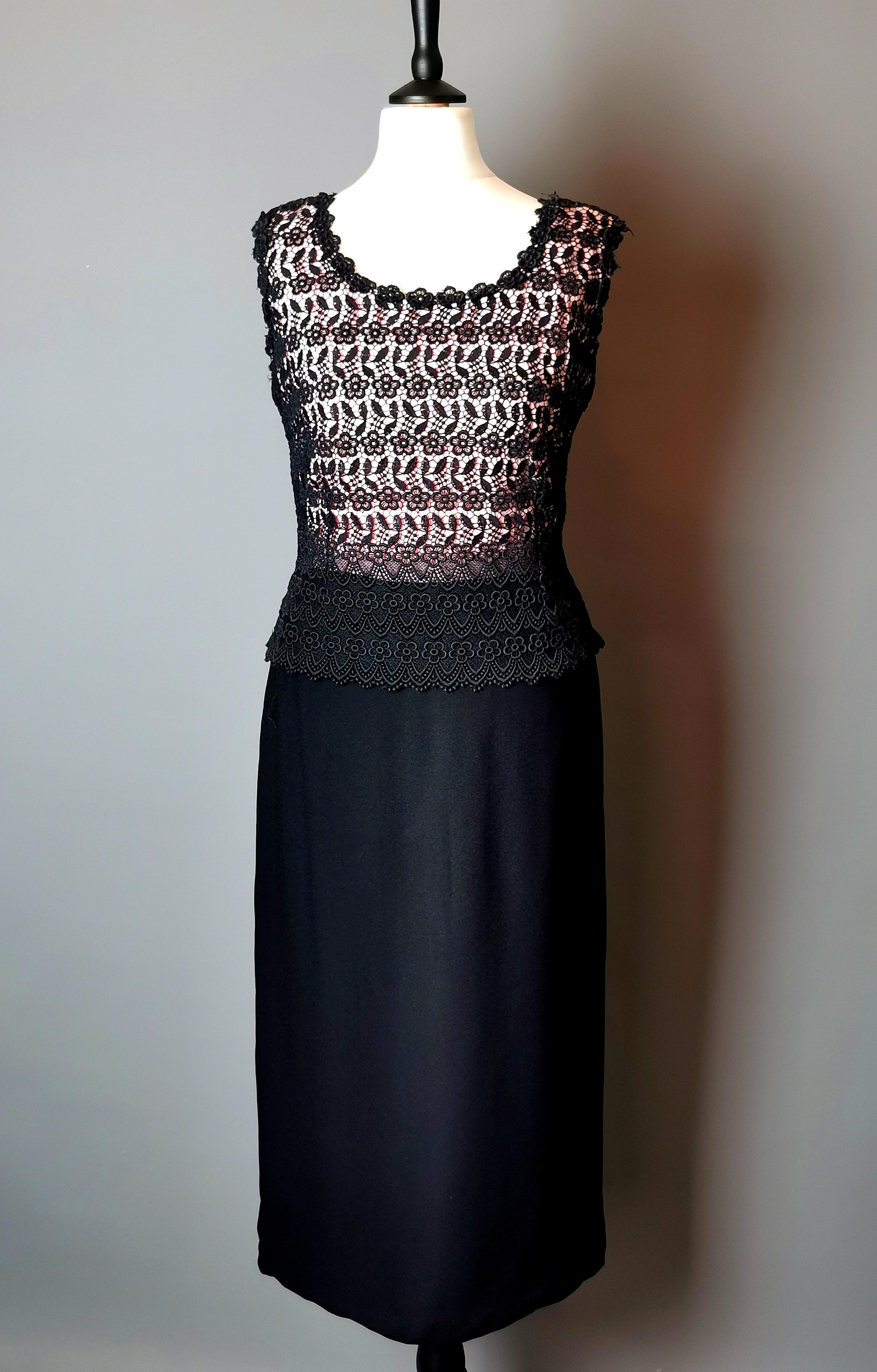 A gorgeous vintage 1970s guipure lace overlay sheath dress.

A figure hugging dress with a sheath silhouette in black with a pink bodice, the pink bodice has a black guipure lace overlay.

It is made from a synthetic fabrics including polyester and