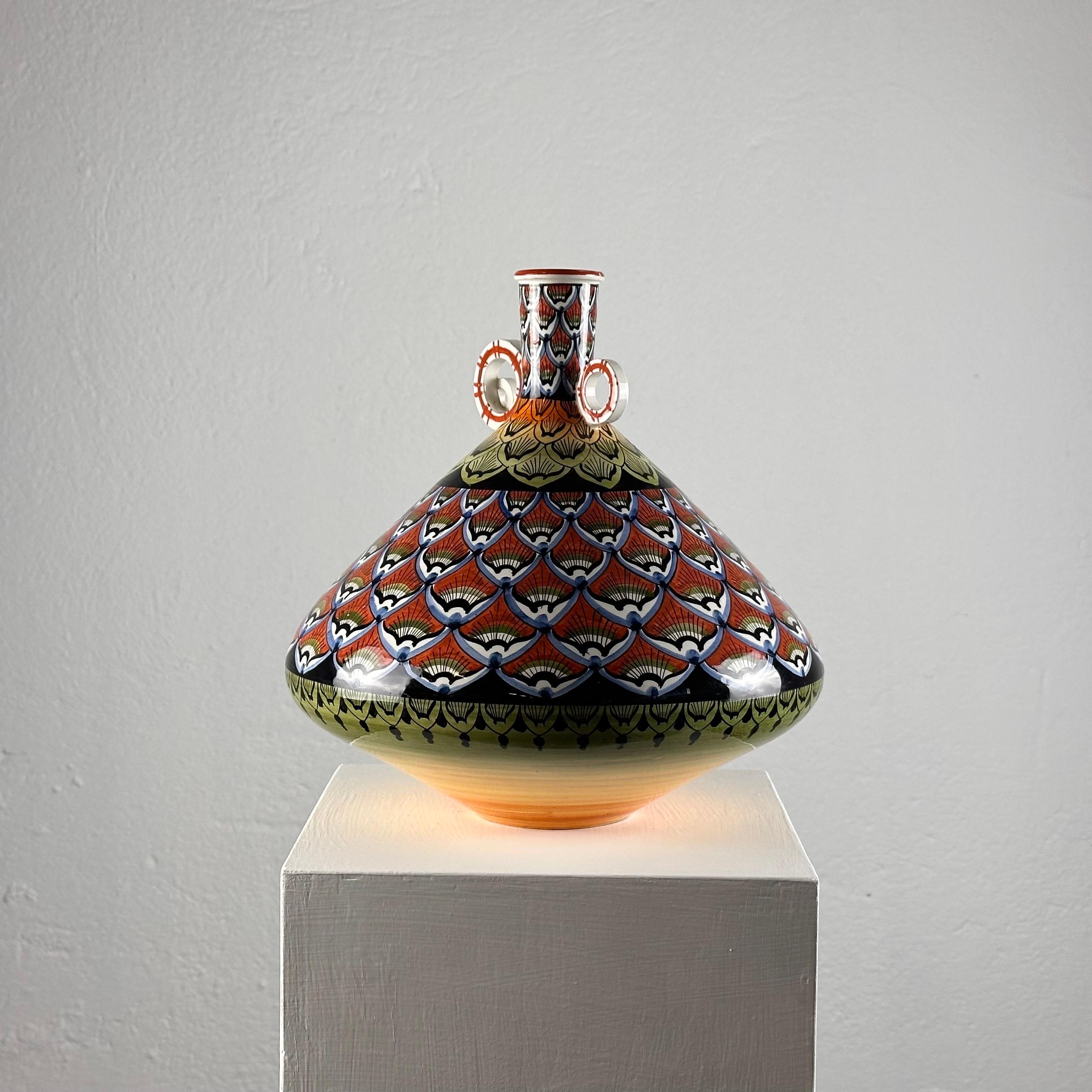 
Transportez-vous dans l'ère vibrante des années 1970 avec ce vase en céramique peint à la main. D'une hauteur de 30 cm et d'un diamètre de 30 cm, cette pièce importante témoigne de l'art de l'époque.

Chaque centimètre de ce vase est orné d'une
