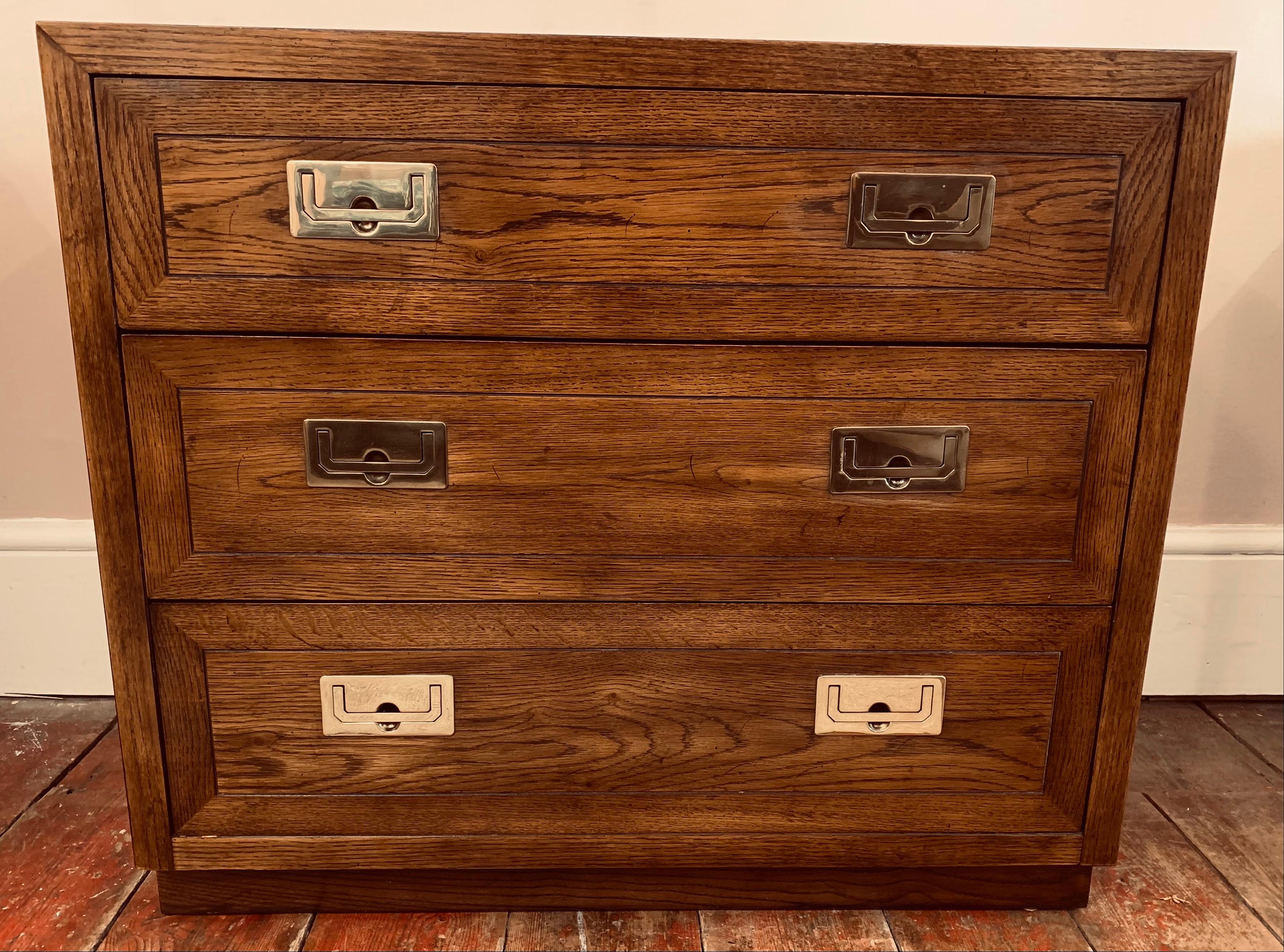 A vintage, 1970s, Henredon USA, Campaign chest of 3 long drawers. Hollywood Regency style. Made from stained Oak, with their original polished brass hardware handles and hinges. The chest is well made, solid and very heavy considering its size. The
