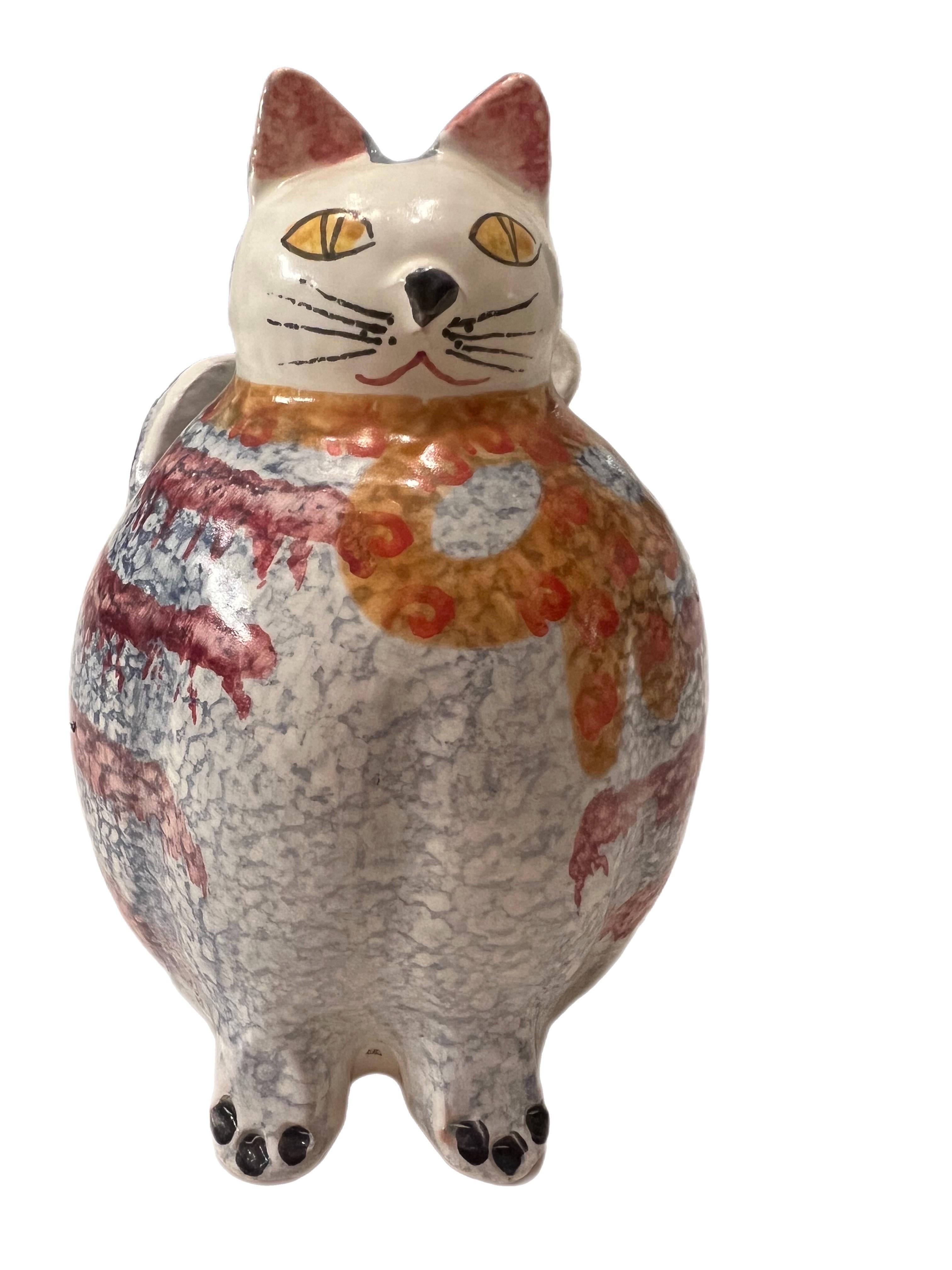 A vintage hand-painted Italian ceramic figural cat vase by Italica ARS. This piece depicts a cute blue and orange striped cat with bow and is marked to underside by maker.  This works as a vase, utensils, makeup brushes…