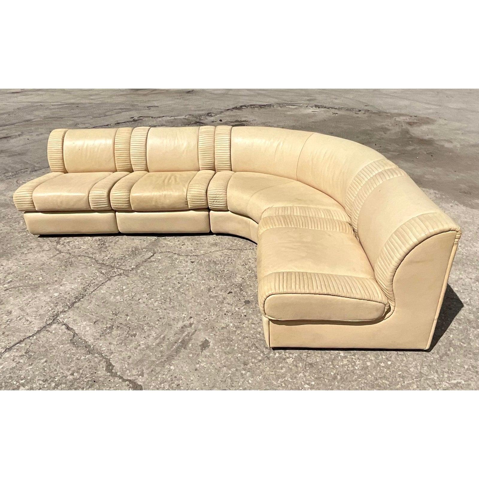 An incredible vintage 1970s sectional sofa. Made by the iconic Italian Casa Bella group. A beautiful creamy color with amazing pleated bands at the end of each section. Tagged on each seat. Four sections total and can be easily reconfigured.