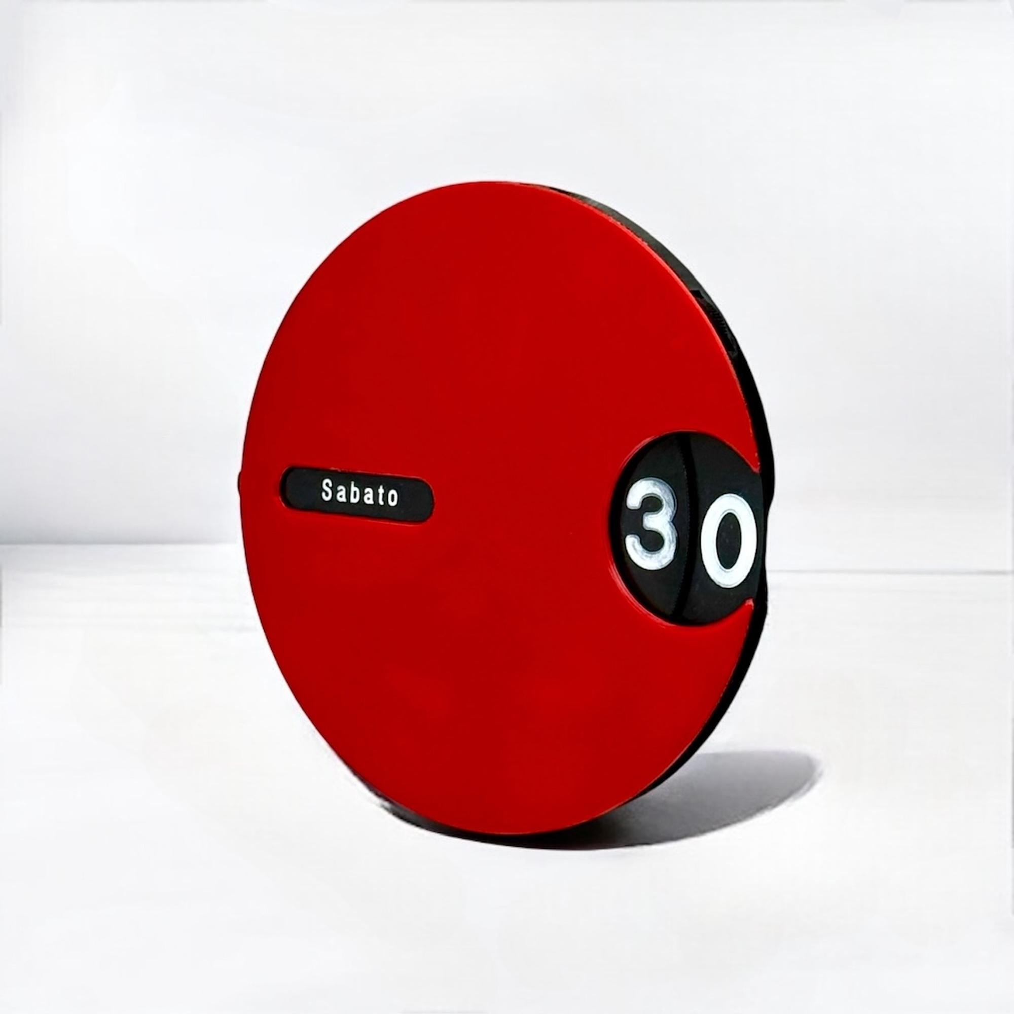 Journey back to the space age era with this rare Italian wall calendar, a true testament to retro-futuristic design. Crafted in the 1970s, this space age calendar features a distinctive red orange body adorned with a rotating black dial, creating a