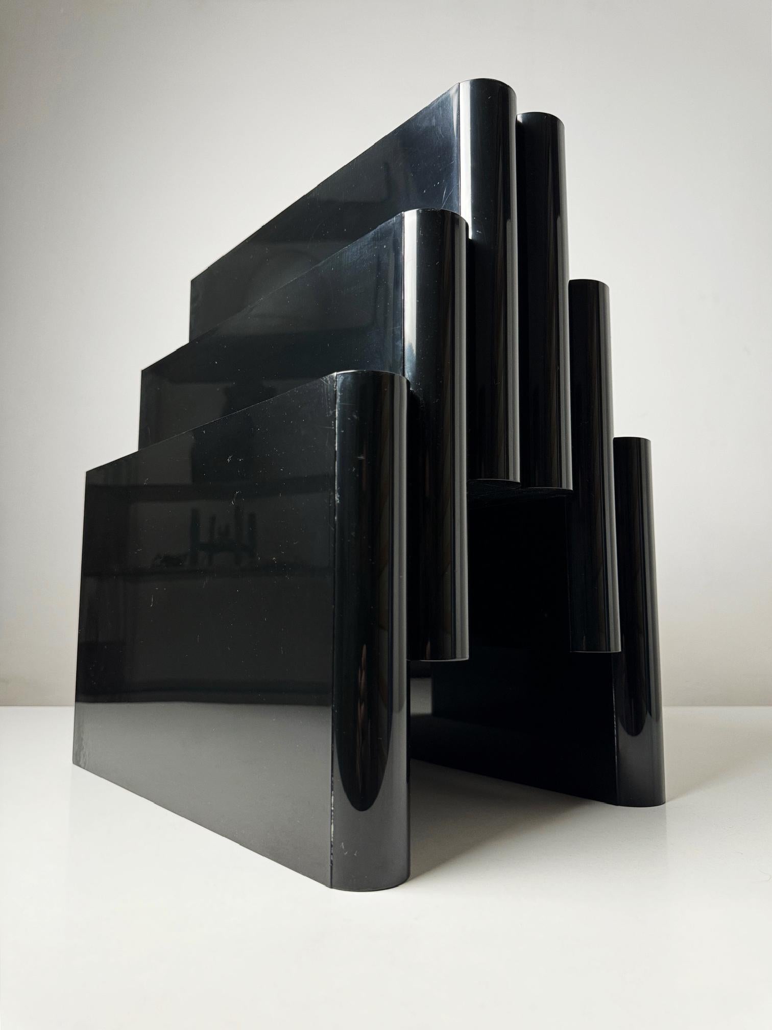 Discover a true piece of design history with this vintage Kartell magazine rack, designed by the legendary Giotto Stoppino in the 1970s. Known for his innovative use of modern materials and minimalist aesthetics, Stoppino’s design for Kartell