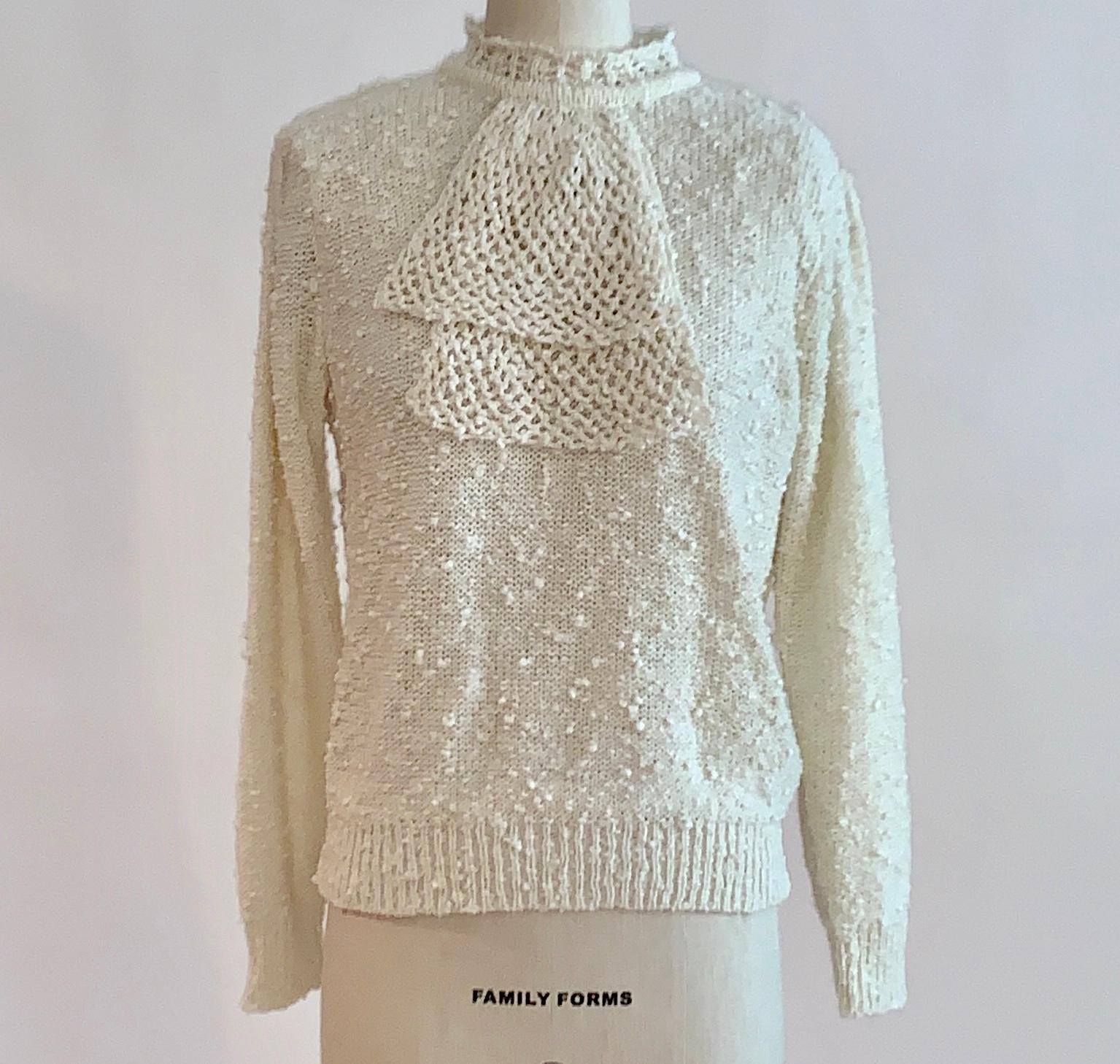 Vintage 1970s cream Le Roy sweater in a wonderful nubby knit with attached jabot collar. Long sleeve, pearlized button closure at back neck. Slightly open-knit, layer for a conservative look or wear alone to show a tiny bit of skin. Right on trend