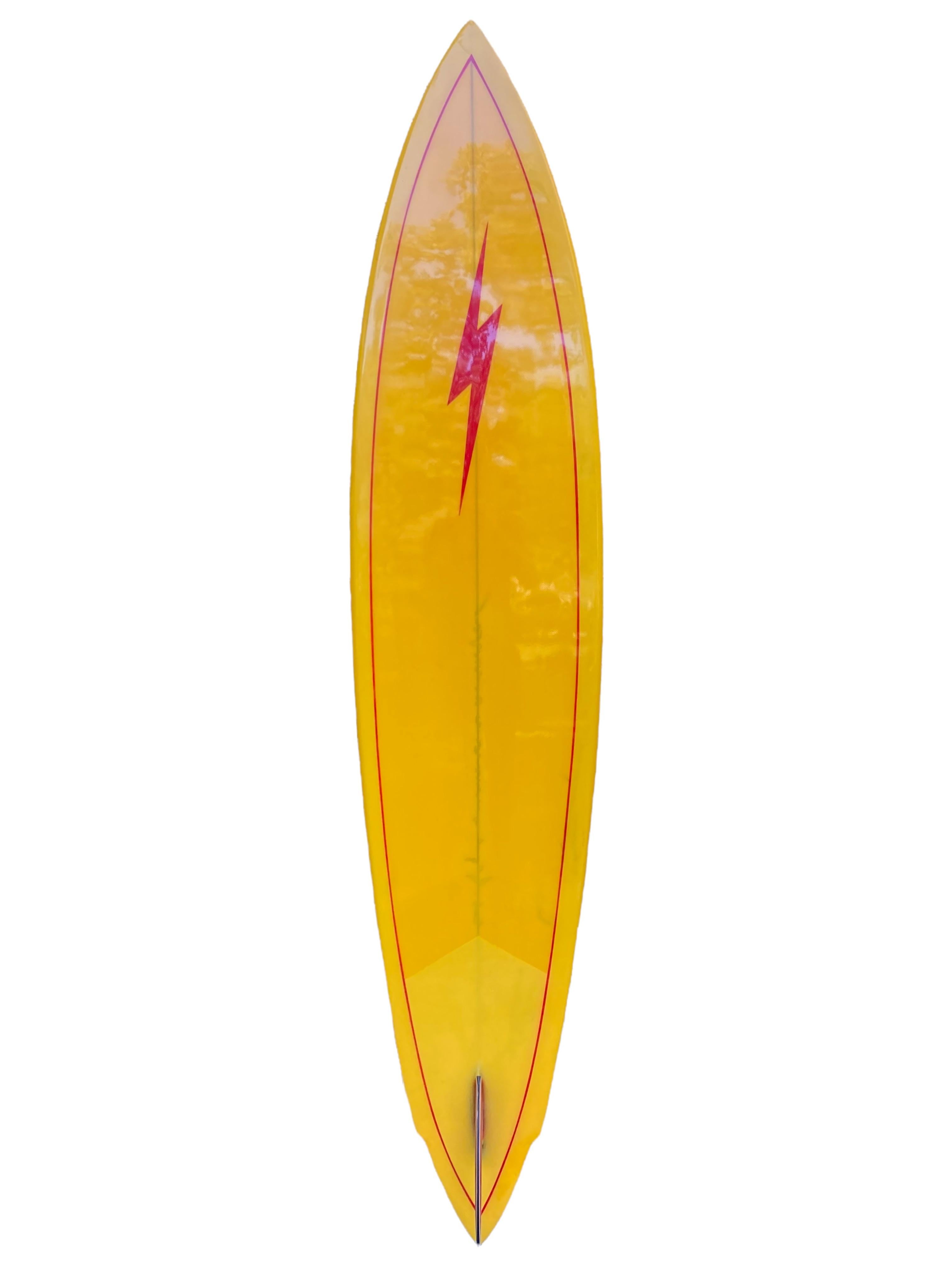 Early-mid 1970s Lightning Bolt Pipeline surfboard shaped by Tom Nellis. Features a vibrant yellow tint and contrasting black lighting bolt jag design with matching black rail lighting bolts. Sharp winged-pintail shape with stunning 5-color glass-on