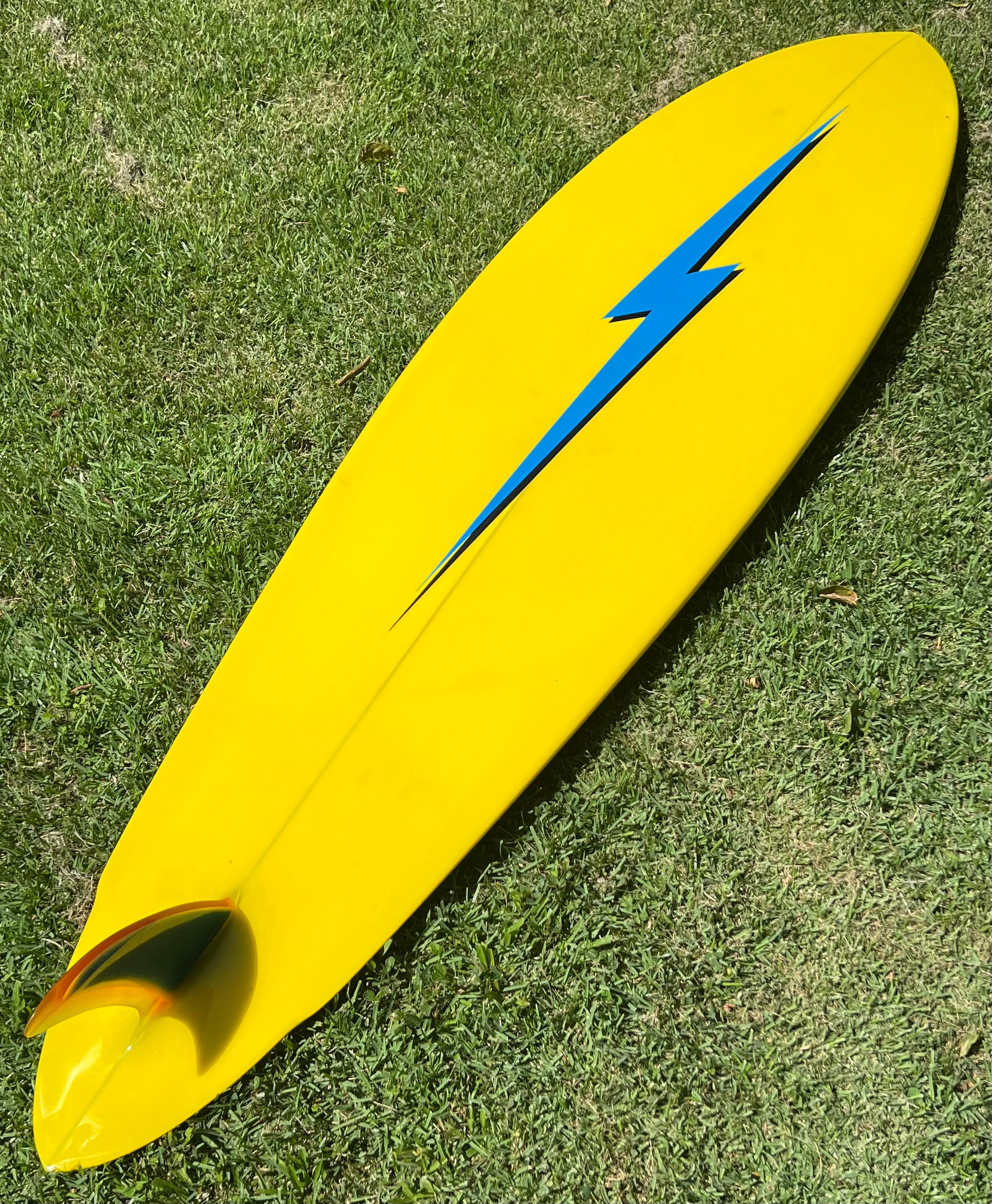 1970s Vintage Lightning Bolt surfboard made by Jim Ellington. Featuring gorgeous light blue deck with bright yellow rails/bottom. Blue pinstripes with amazing original 3 color fixed single fin and winged pintail. Ellington was taught the craft of