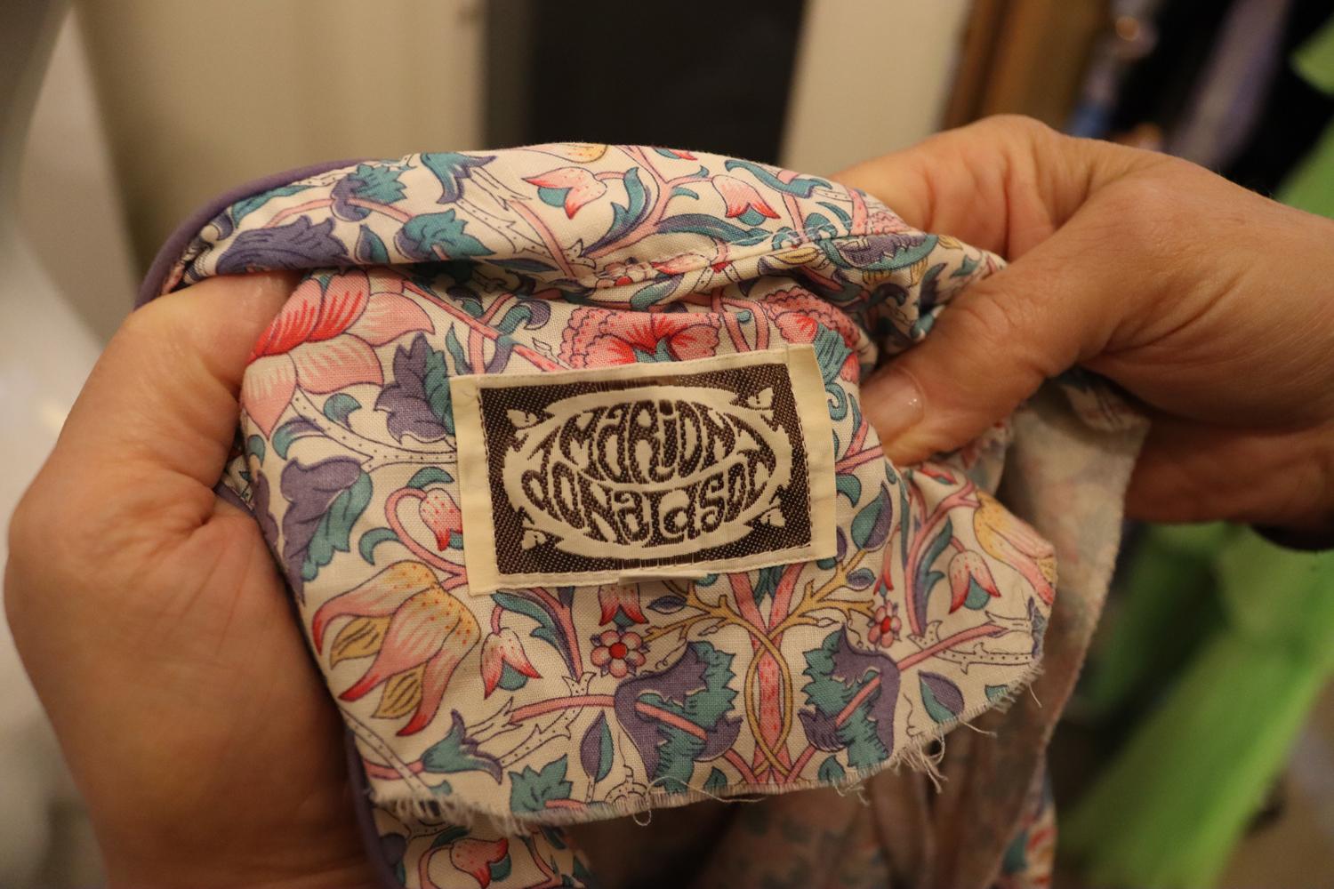 A very pretty vintage floral dress by Marion Donaldson. The dress dates from the 1970s , and is made of cotton with an ivory background and pretty floral print, in pink , lilac and turquoise. It has a stand up collar with lilac piping, a button