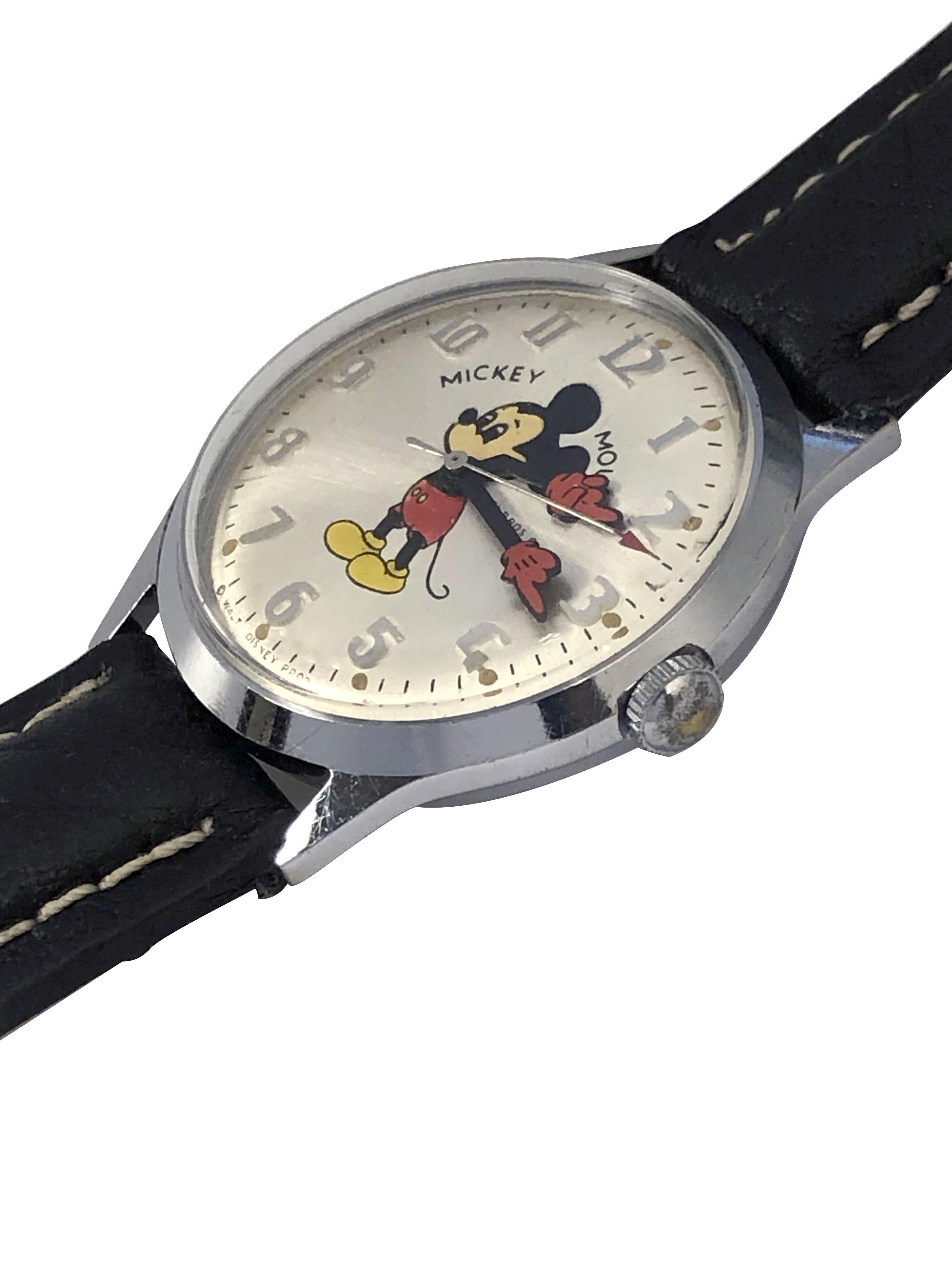 Circa 1970s Mickey Mouse Wrist Watch by Helbros, 23 M.M. Stainless Steel 2 piece case with Water proof back. 17 Jewel, mechanical, manual wind movement. Silver Satin dial with raided markers, Enamel printed Mickey and animated Enamel Mickey Gloved