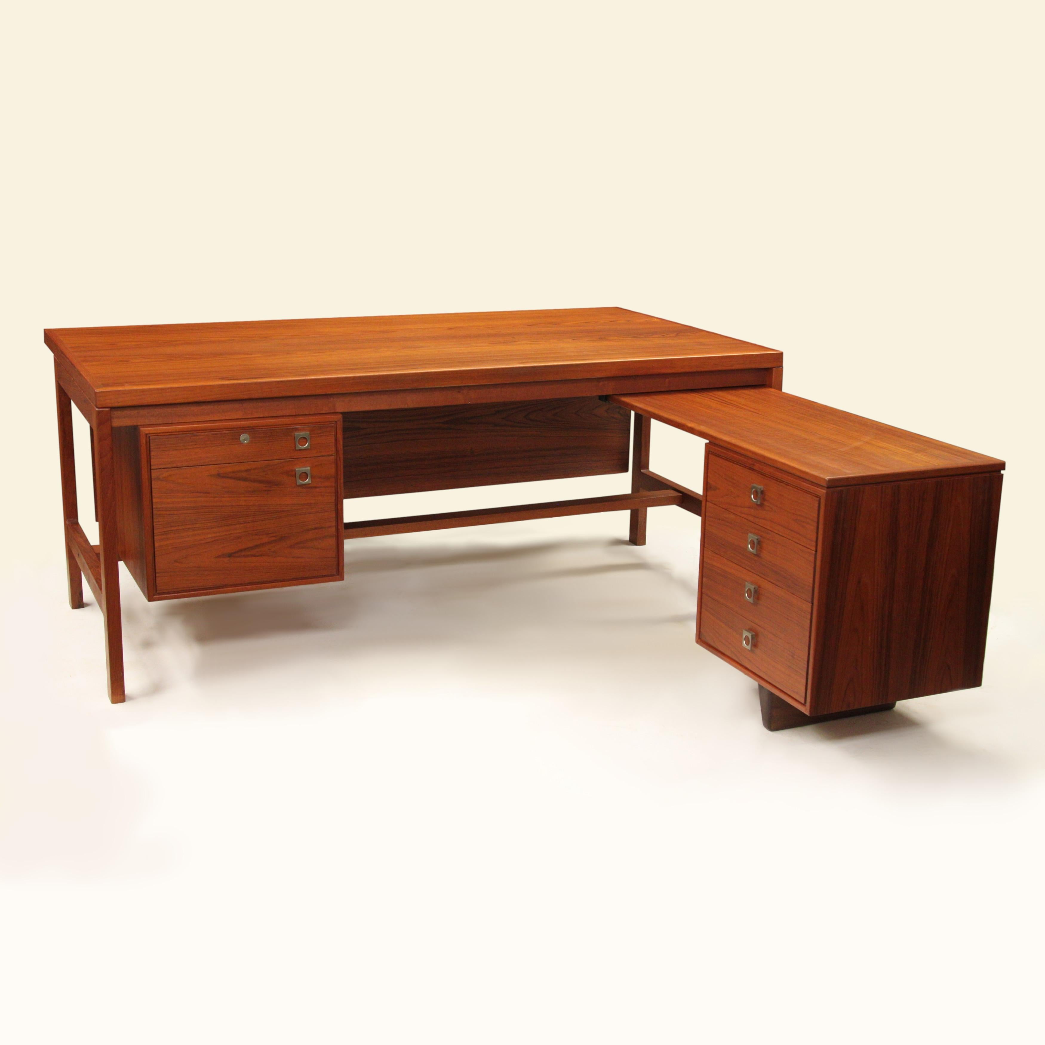 This is a wonderful executive desk designed by Arne Vodder for Danish furniture manufacturer H.P. Hansen. 

Desk Features:

- Book-matched teak veneer
- Solid teak frame
- Brushed aluminum hardware
- Six drawers
- L-Shaped design with