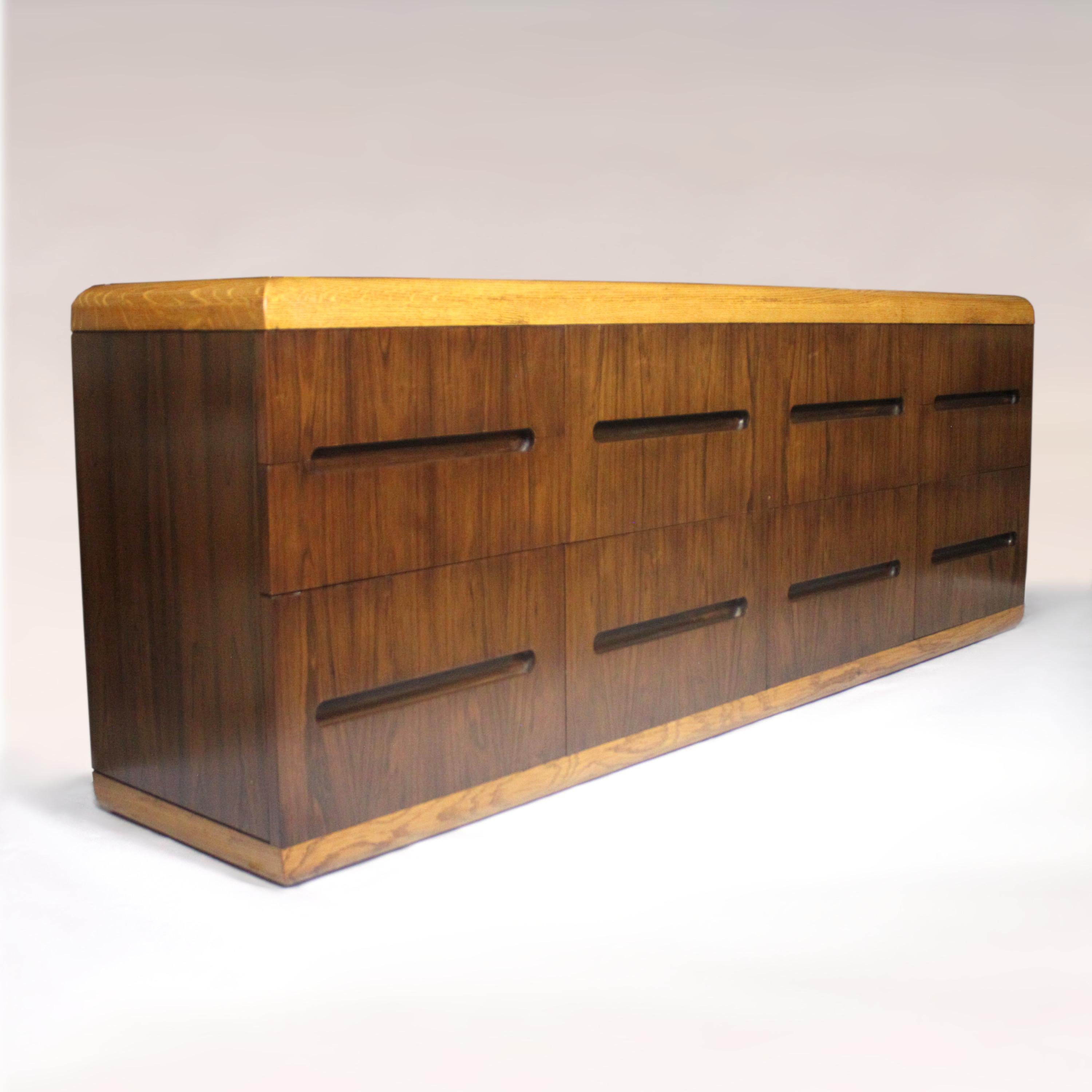This beautifully-made credenza features a design reminiscent of Roger Sprunger  and the unparalleled build-quality for which Dunbar is renowned. The clean, Minimalist lines are complimented perfectly by the contrasting oak and rosewood veneers. With