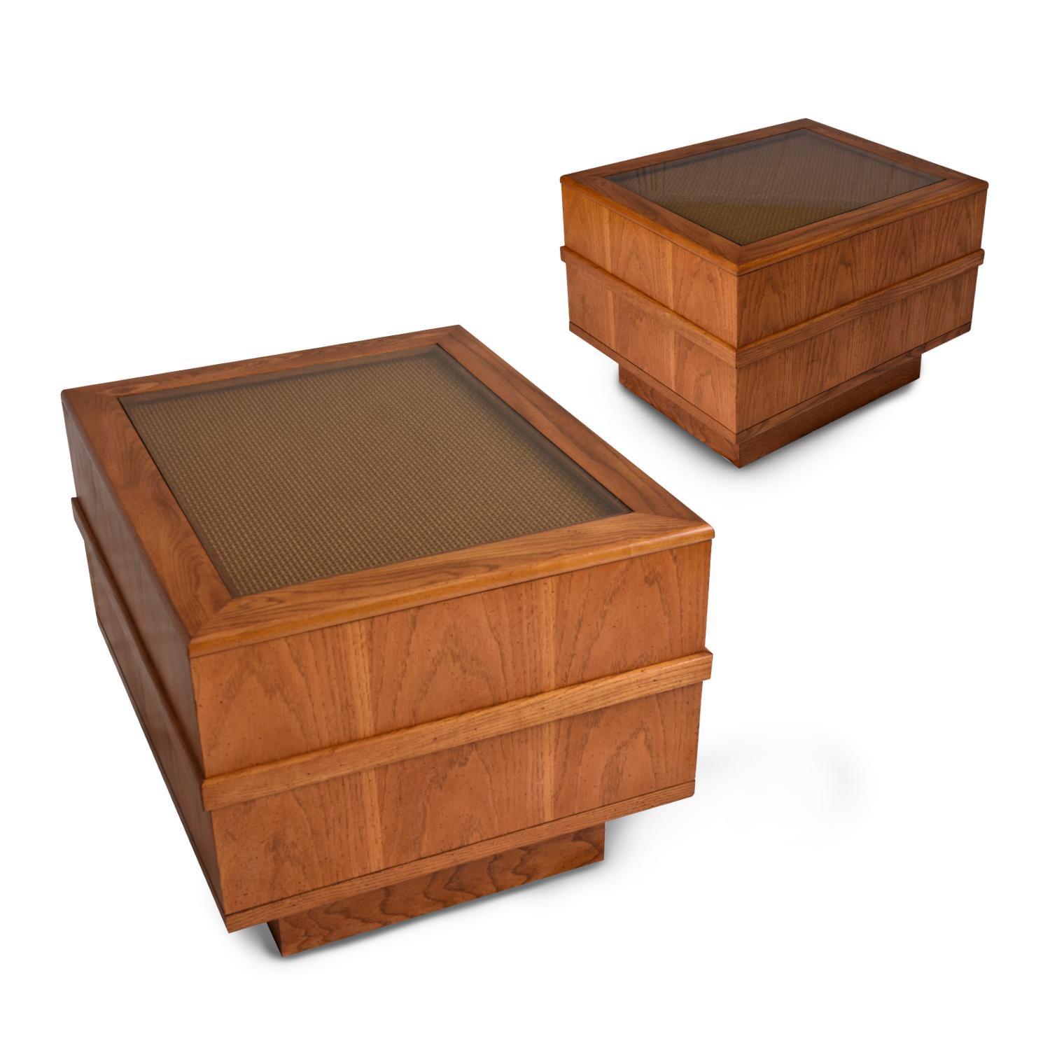 Pair of vintage 1970s monumental end tables with glass covered cane tops. The obtuse profile of these vintage tables speaks directly to the 1970s aesthetic. The large rectangular cubes are made of oak with an elegant fly speck finish. A single band