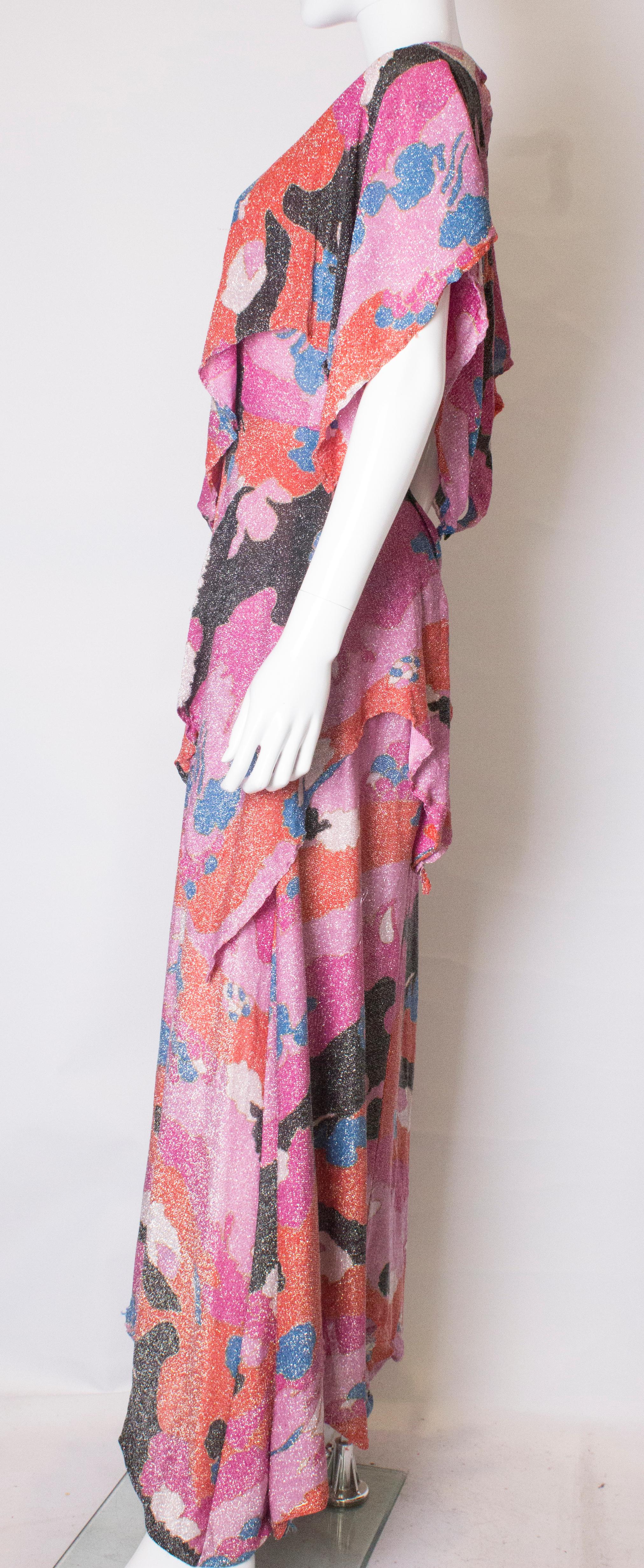 A pretty multi colour lurex evening gown from the 1970s. The dress is in a wonderful mix of pink, blue , orange, black and ivory. It has a central back zip.