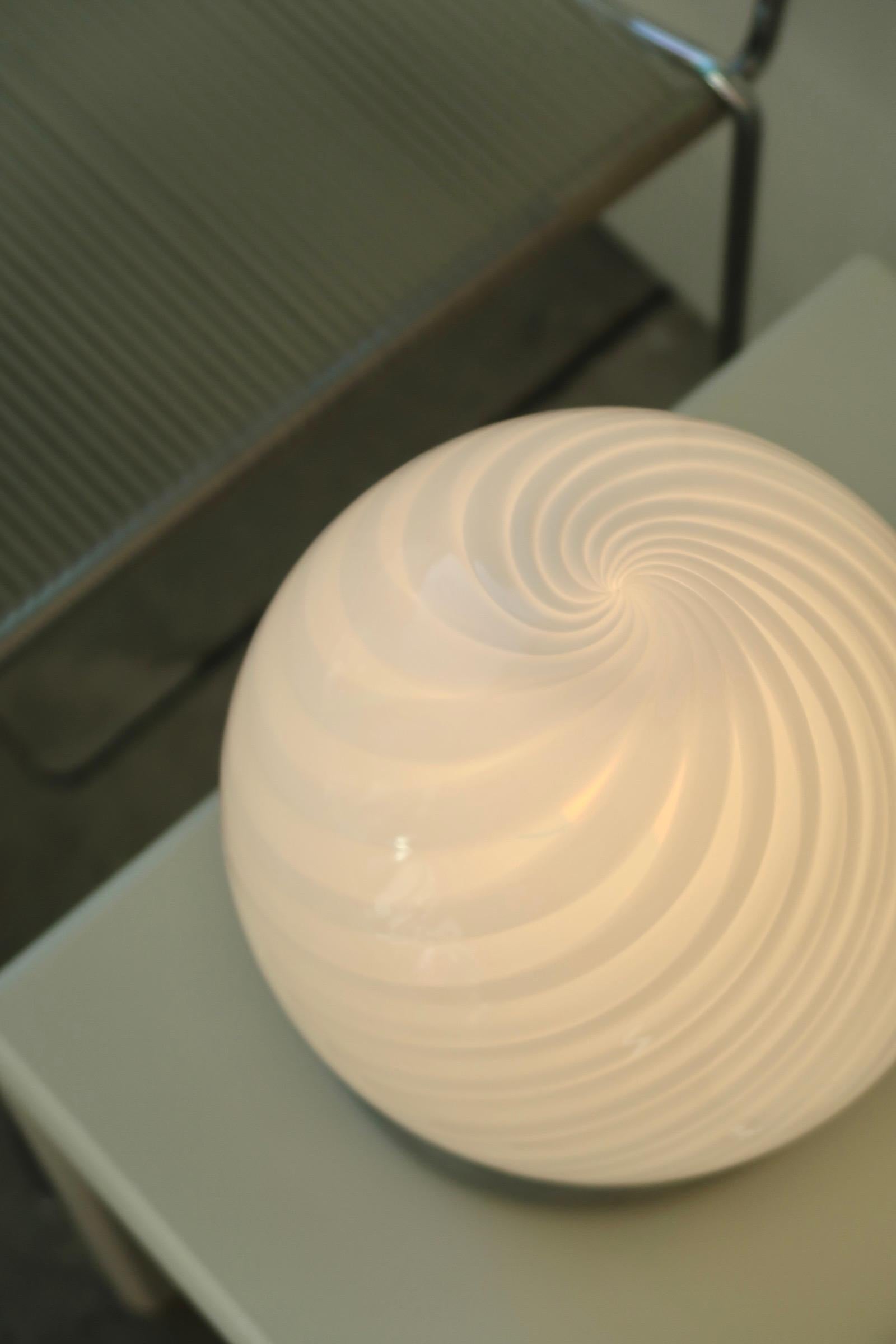 Vintage Murano lampe de table, soufflée à la bouche en verre blanc avec tourbillon. Fabriqué à la main en Italie, dans les années 1970, et livré avec un nouveau cordon blanc.

H:23 cm D:20 cm.

