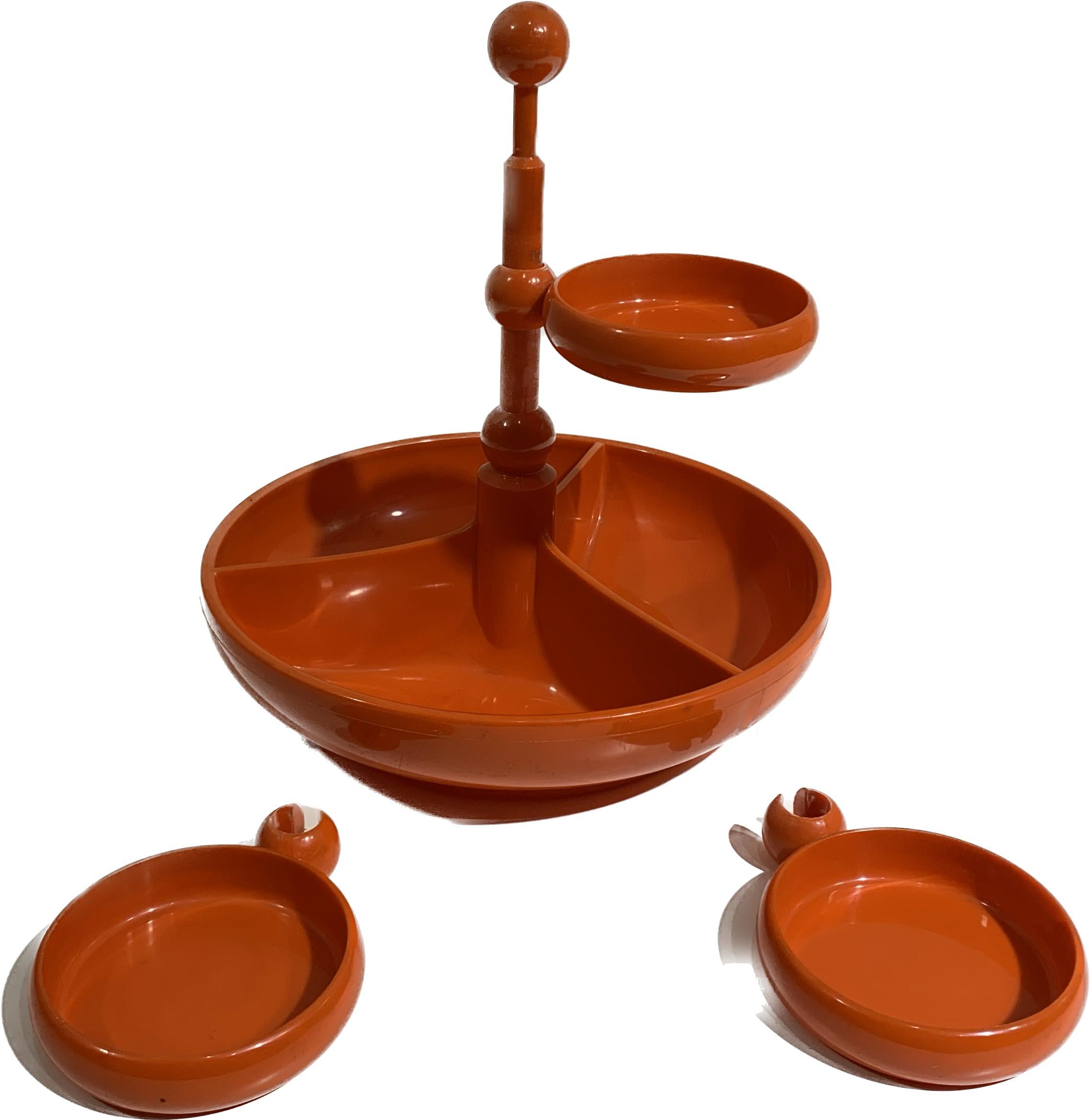 Very nice vintage orange snack tower with rotating platters made from ABS plastic.
The main central bowl holds three divided compartments that are fixed and there are three rotating smaller plates above where you can store all sorts of gooodies.