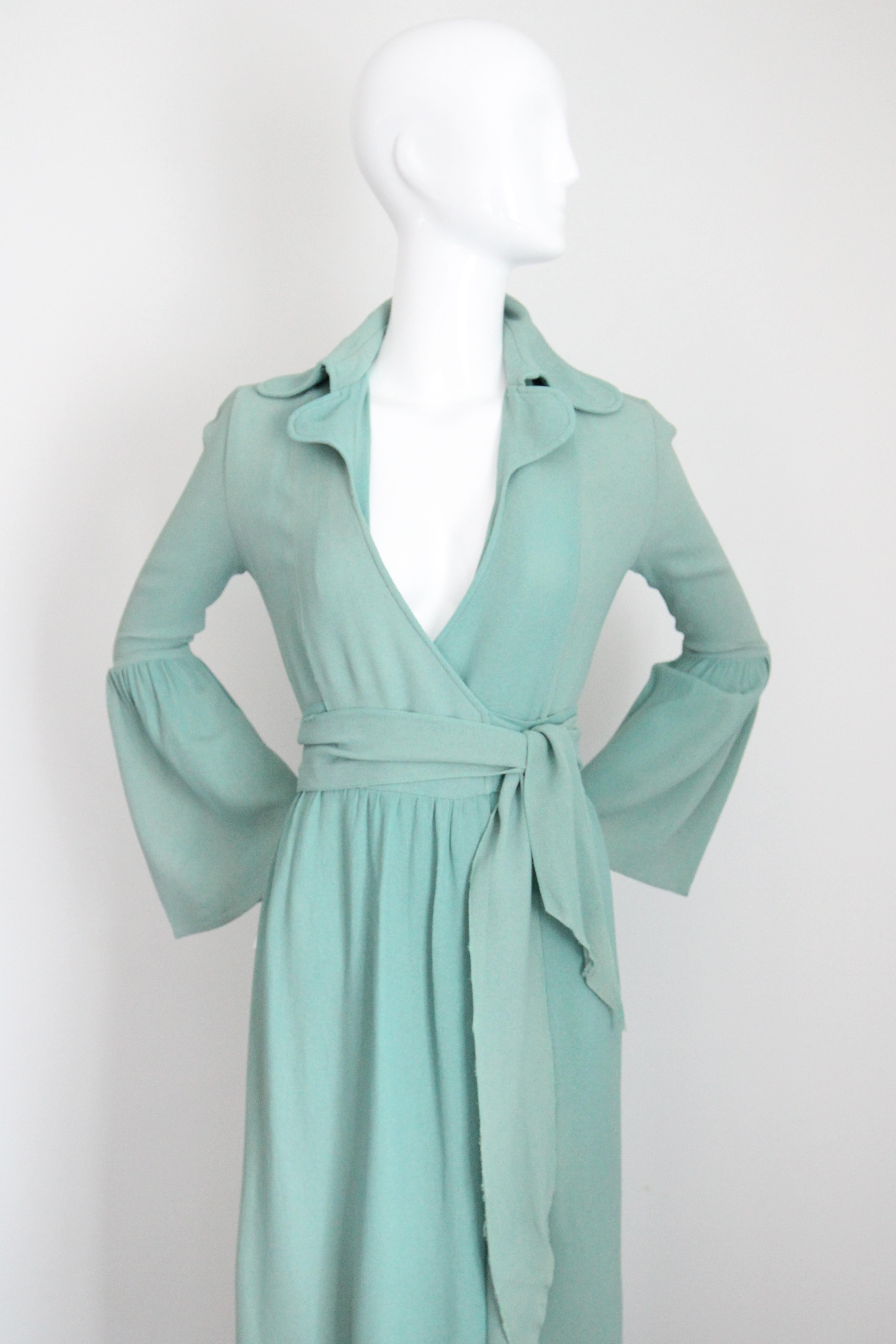This truly iconic 1970's Ossie Clark moss crepe dress in the softest shade of Eau De Nil, is the perfect piece to add to your collectable and classic vintage wardrobe.  

The deep V shaped neckline, is framed by a notched dog ear collar. The simple