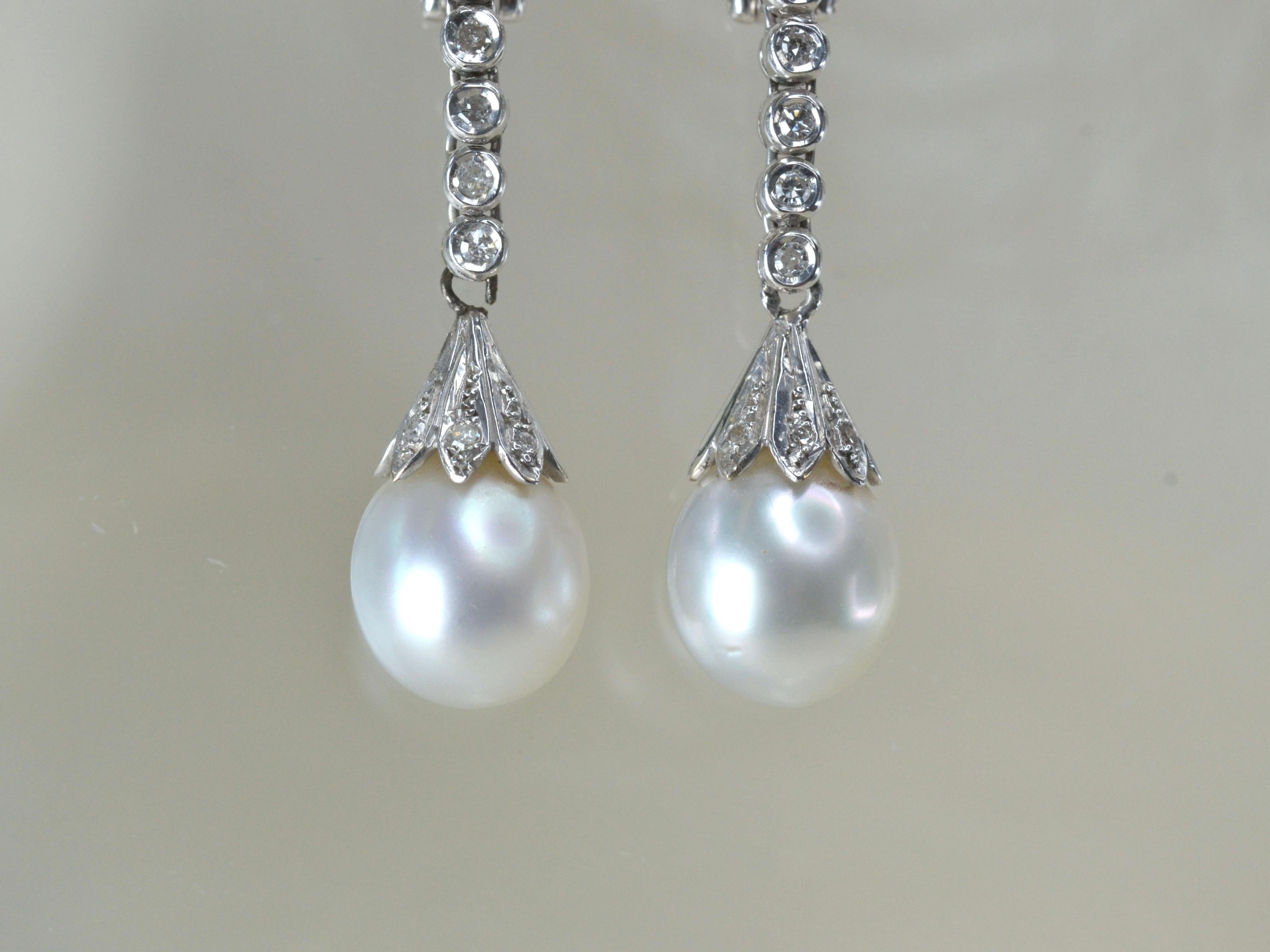 1970er Jahre Clip auf Ohrringe baumeln. 
Jeder tropfenförmige Ohrring besteht aus einer großen weißen Perle und 20 runden weißen Diamanten, die in 9 Karat Weißgold gefasst sind. Diese eleganten Ohrringe sind in sehr gutem Zustand, sie sind leicht