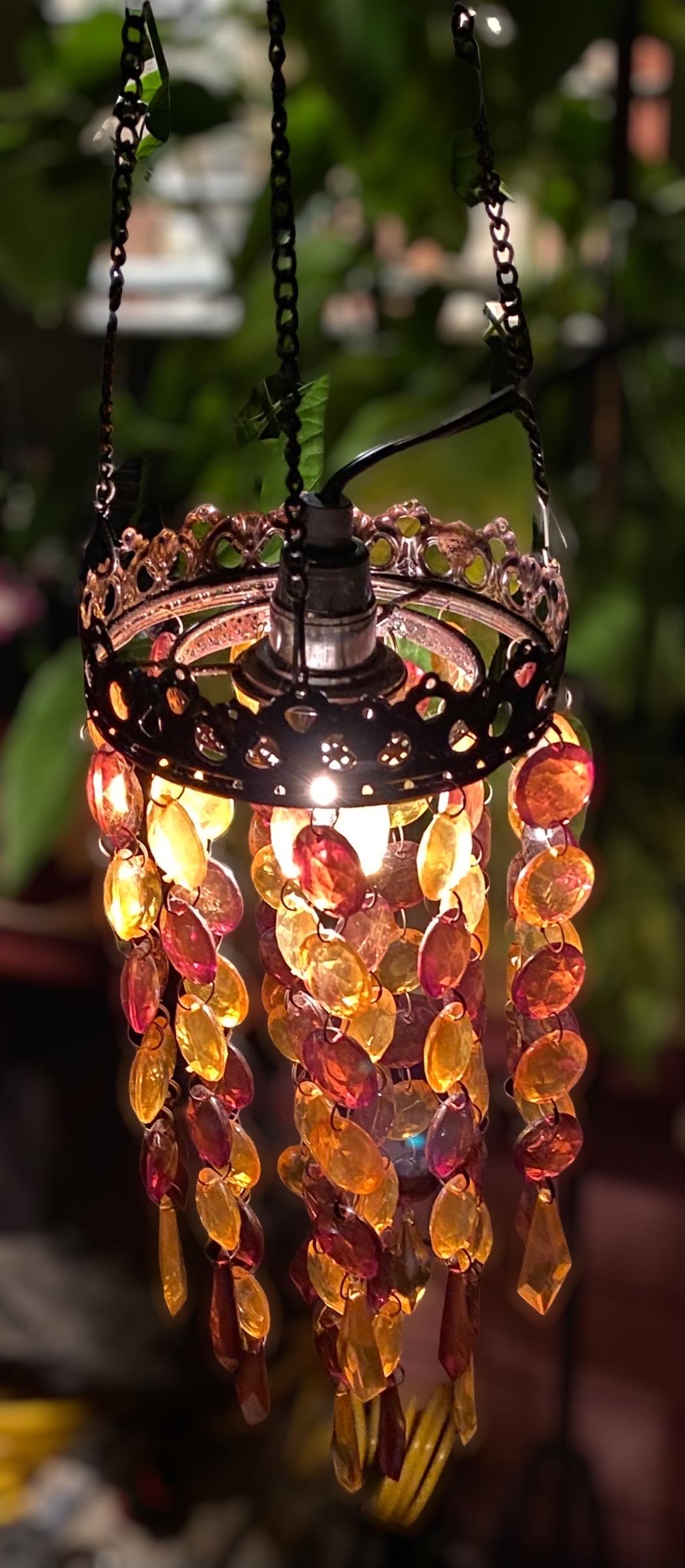 Groovy 1970s petite pendant chandelier with graduated gold and amber colored lucite prism’s and pierced patinated metal rims. Suspended by three chains the fixture simply plugs in to an electric outlet. 
Twenty strands of eight strings on inner ring
