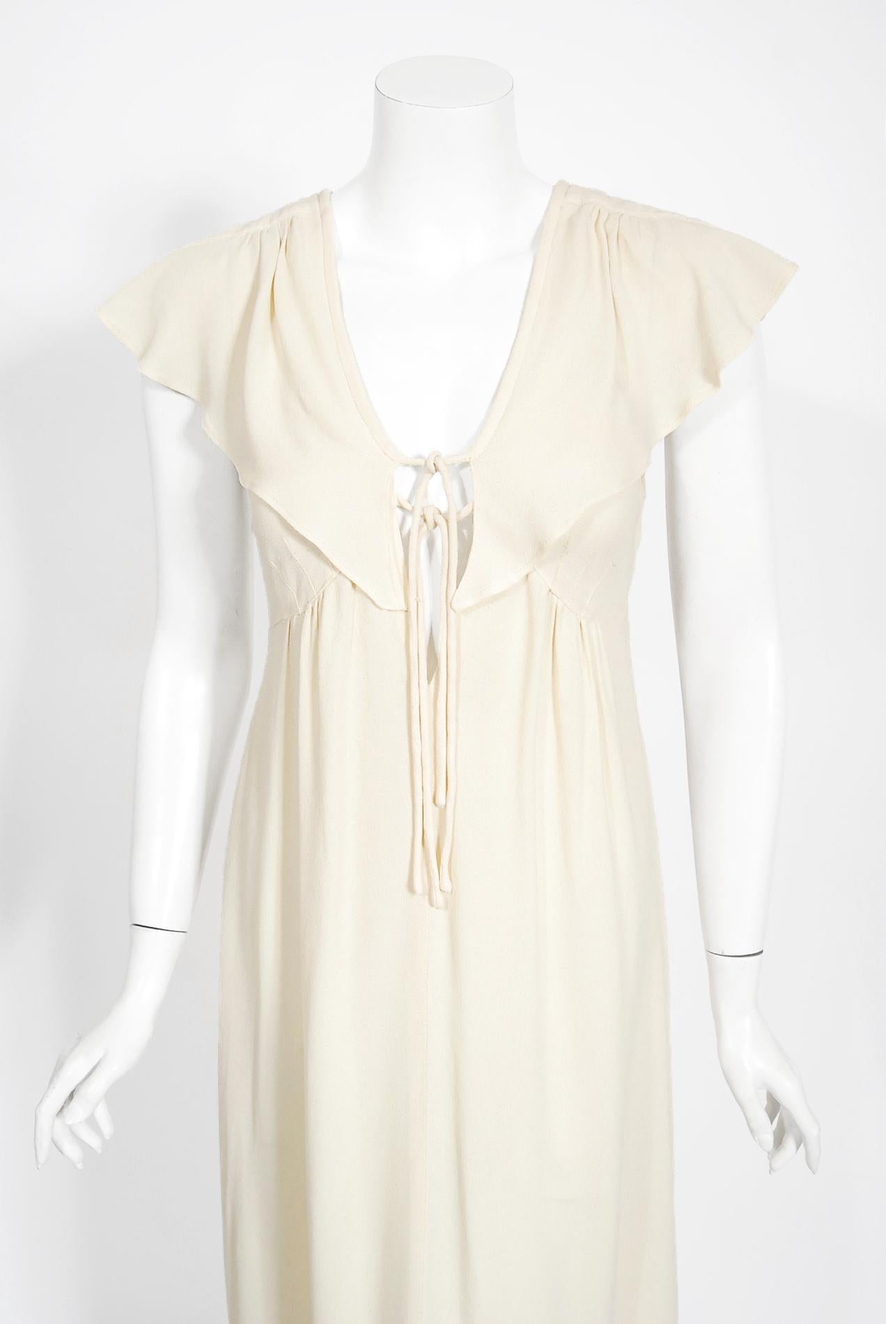 An ethereal and totally timeless Radley of London ivory moss-crepe flutter sleeve capelet dress dating back to the mid 1970's. Radley was a British clothing company that started in the late 1960's and is best known for its association with the