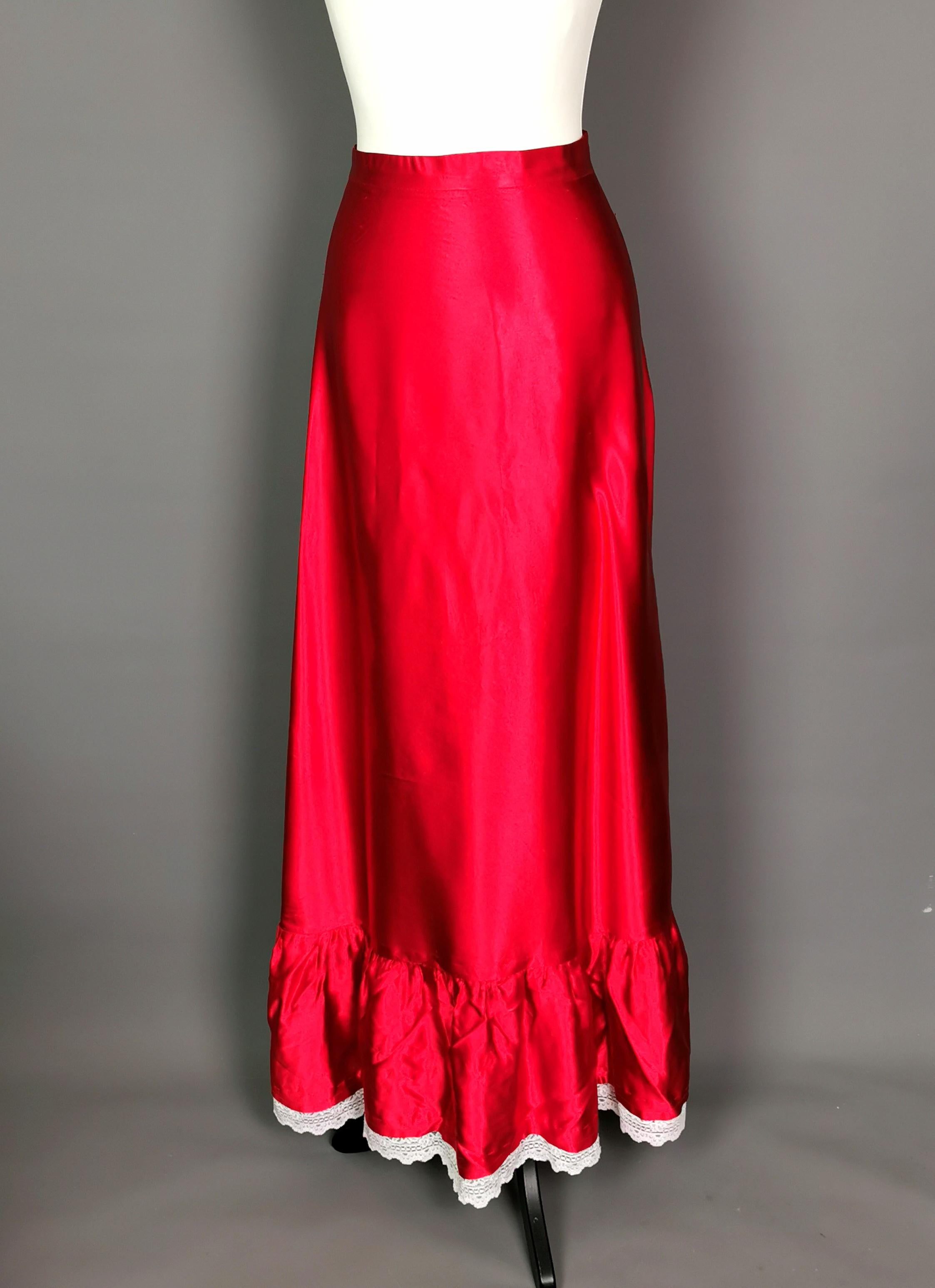 A stunning rare vintage 1970's evening skirt.

Made by Mr Ant Boutique in the UK in the 1970s from deep warm red satin, the red is a slightly warmer red than the images.

It has a gorgeous silhouette with a long flowing swishy skirt perfect for the