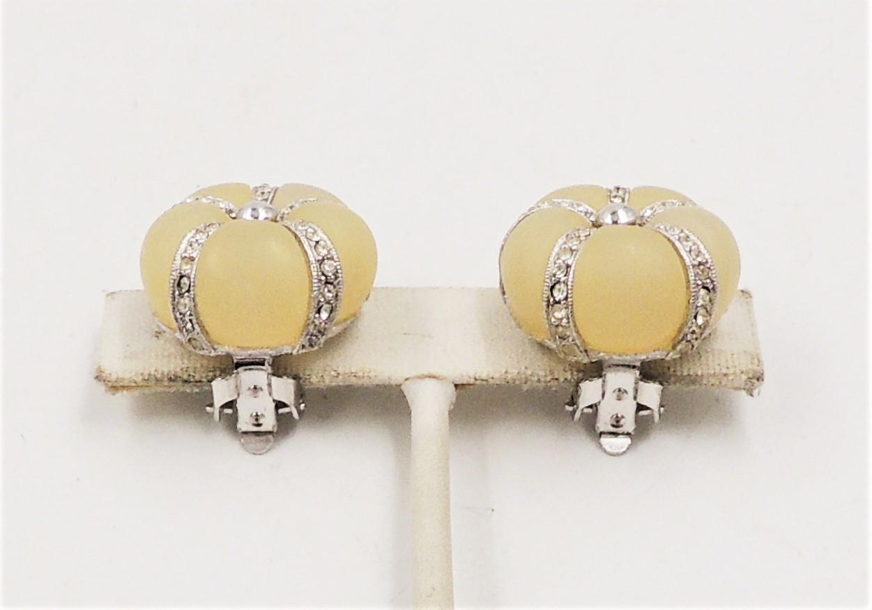 1970s rhodium plated pale yellow Lucite domed with clear rhinestone accents clip earrings. Marked 