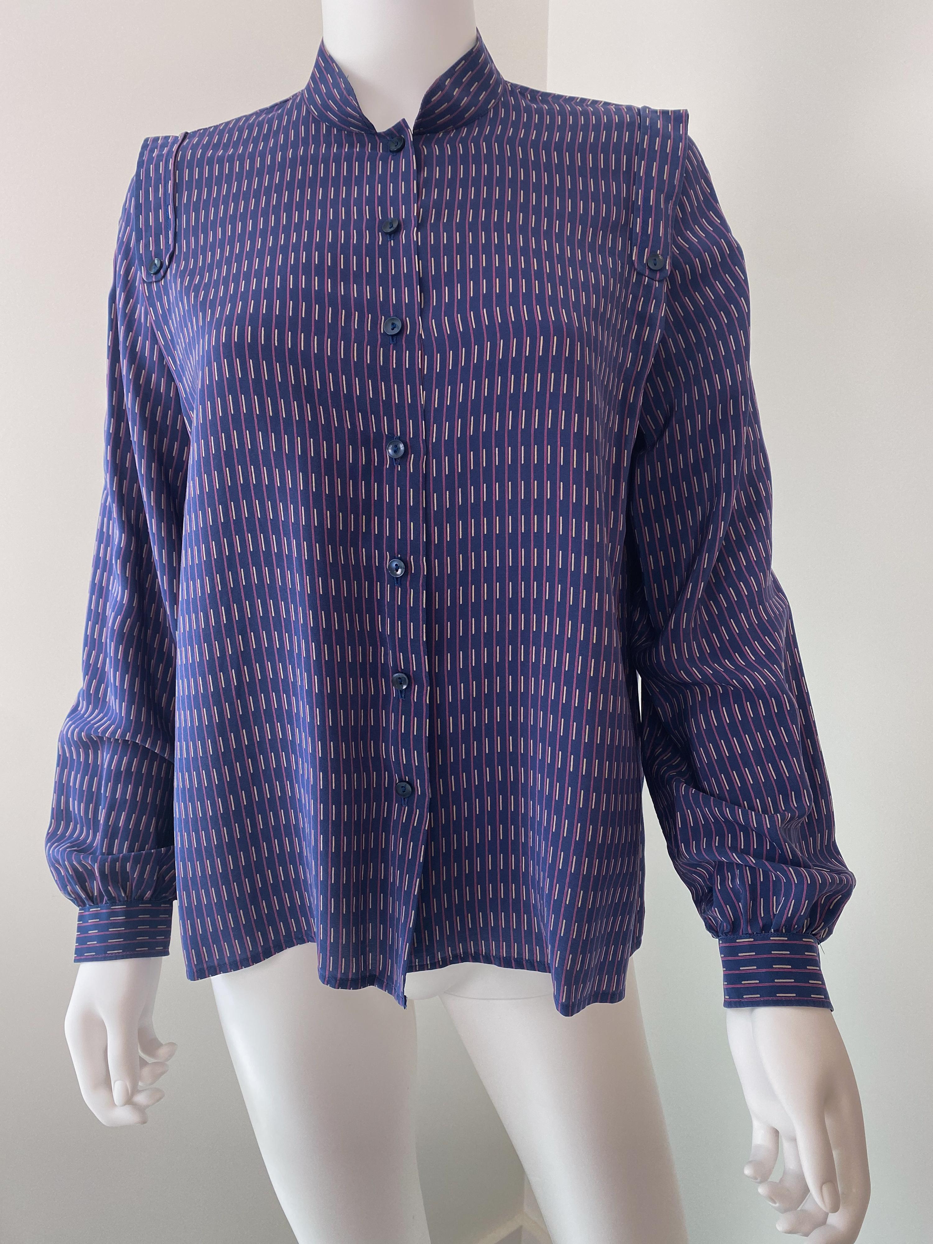 Favolosa camicetta vintage anni '70 in 100% seta, top. Tessuto viola e blu con stampa di motivi geometrici in contrasto rosa e bianco. I polsini sono leggermente pieghettati per dare volume. Il busto della blusa si allarga con un design strutturato