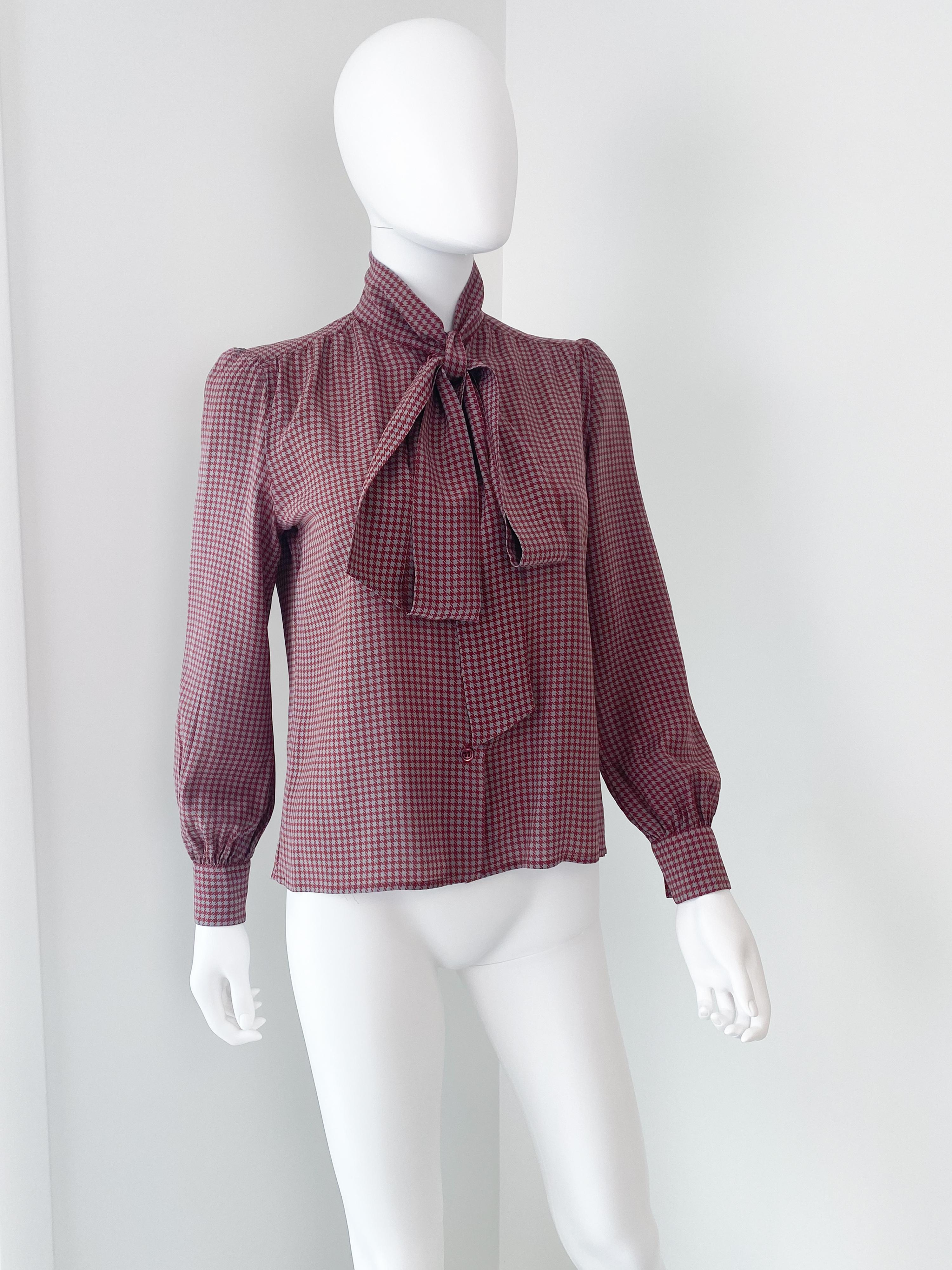 Fabulosa blusa vintage de los años 70, 100% seda, con lazo. Tejido de color rojo burdeos y gris ratón con estampado de pied de poule y pañuelo-moño extra largo adjunto. Hay un suave plisado en la parte delantera, la espalda y los puños con botones