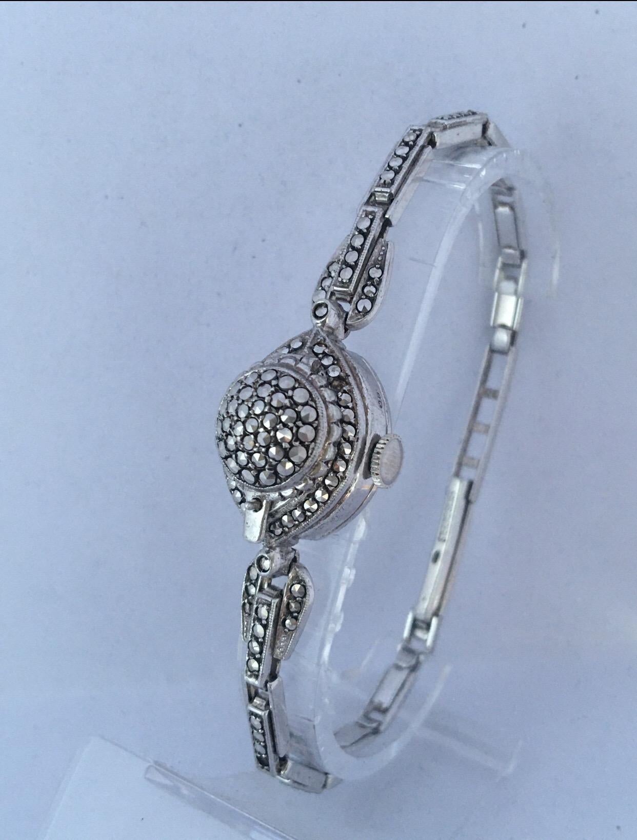 This beautiful vintage hand winding silver bracelet watch is in good working condition and it is running well. Visible signs of ageing and wear with small and light marks on the case  as shown. the watch glass is missing as shown. 1 seed is missing