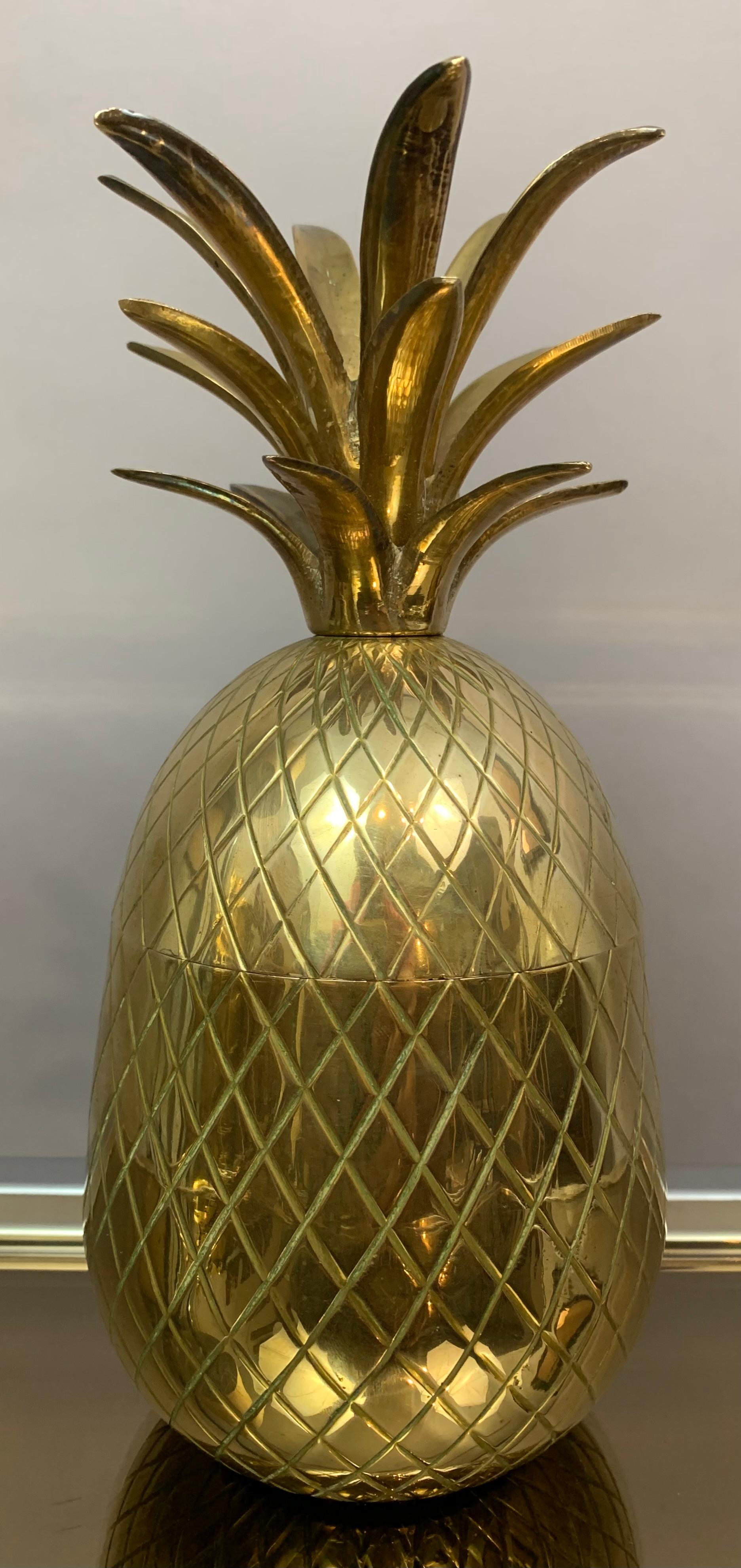 Circa 1970s Vintage Hollywood Regency polished brass pineapple ice bucket. The surface of the outside is decorated with an incised diamond pattern. The ice bucket separates in two allowing access to whatever you decide to keep inside. 

In very