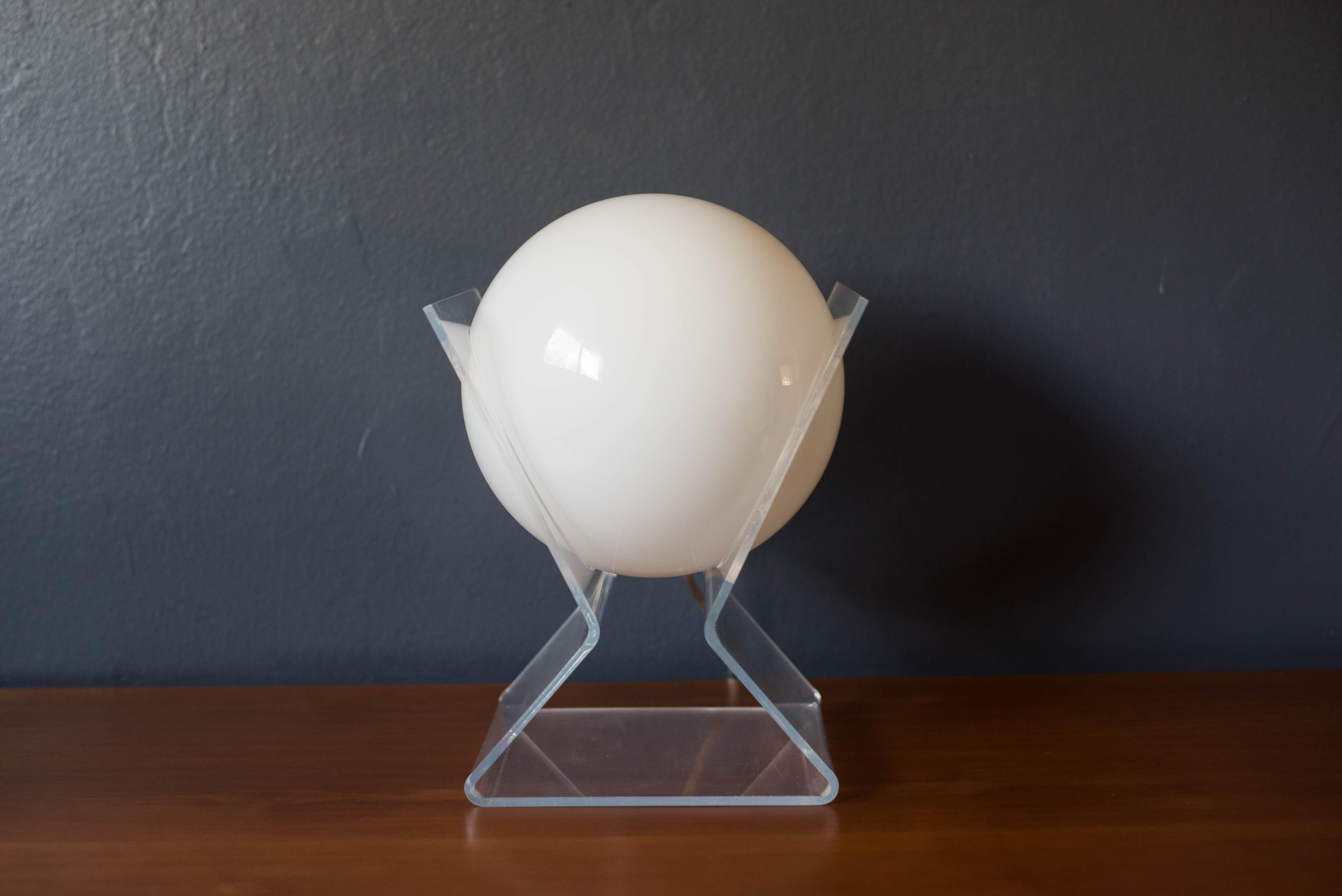 Mid-Century Modern accent globe table lamp, circa 1970s. This piece features a floating moon glass globe that emits a soft glow supported by a lucite angular frame. 


