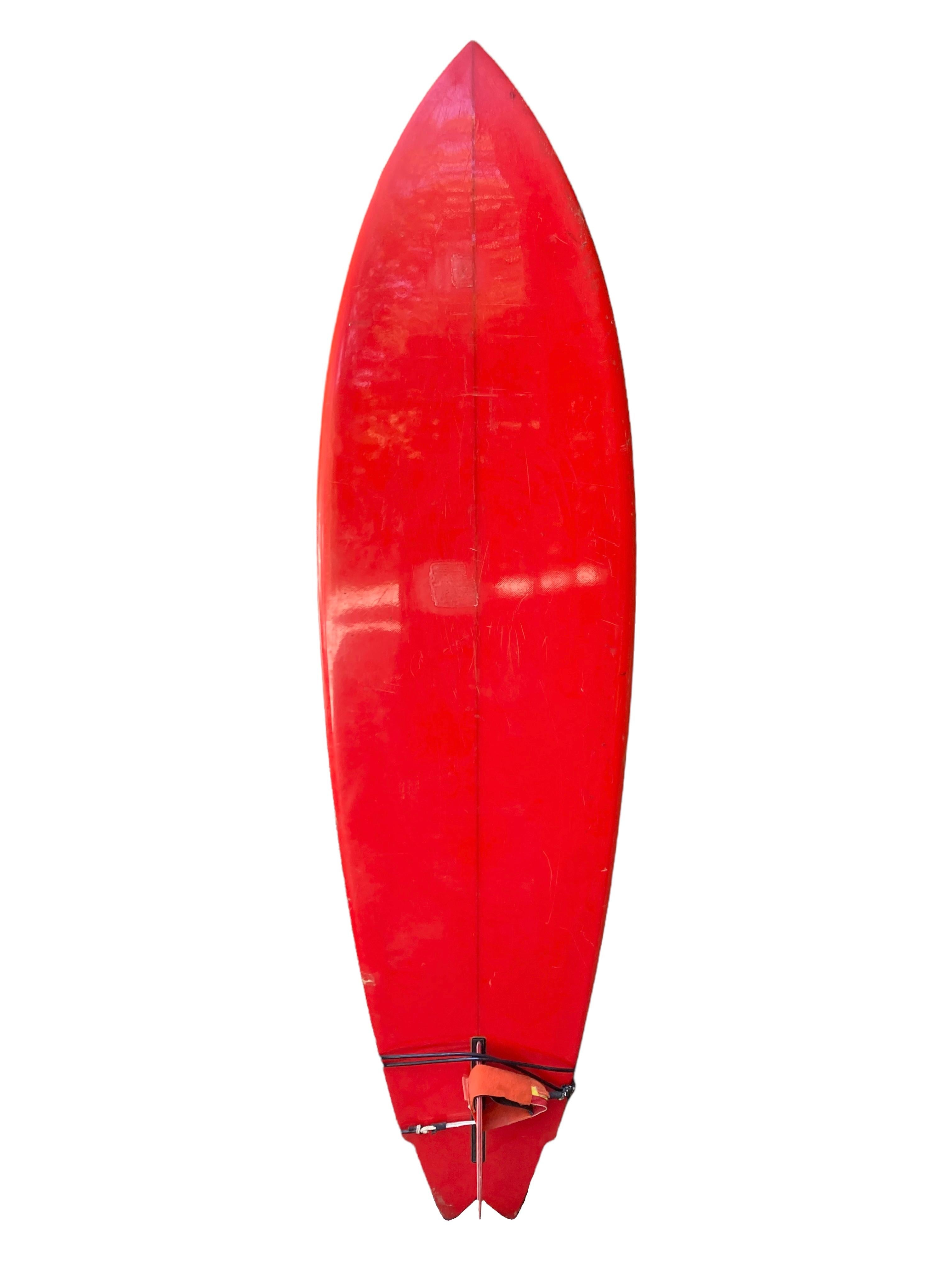 Early-1970s Sunset Surfboards classic single fin. Features a beautiful orange tint with pinstriped outline including lightning bolt jag design along the rails. Winged swallow tail shape with original box single fin. Includes an early leg leash which