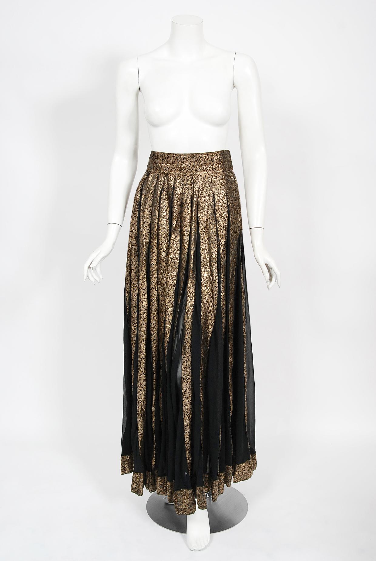 An absolutely gorgeous and incredibly rare Thea Porter couture metallic gold lamé and semi-sheer silk chiffon maxi skirt dating back to the early 1970's. The design is truly incredible; wide panels of black silk chiffon framed by luxurious paisley