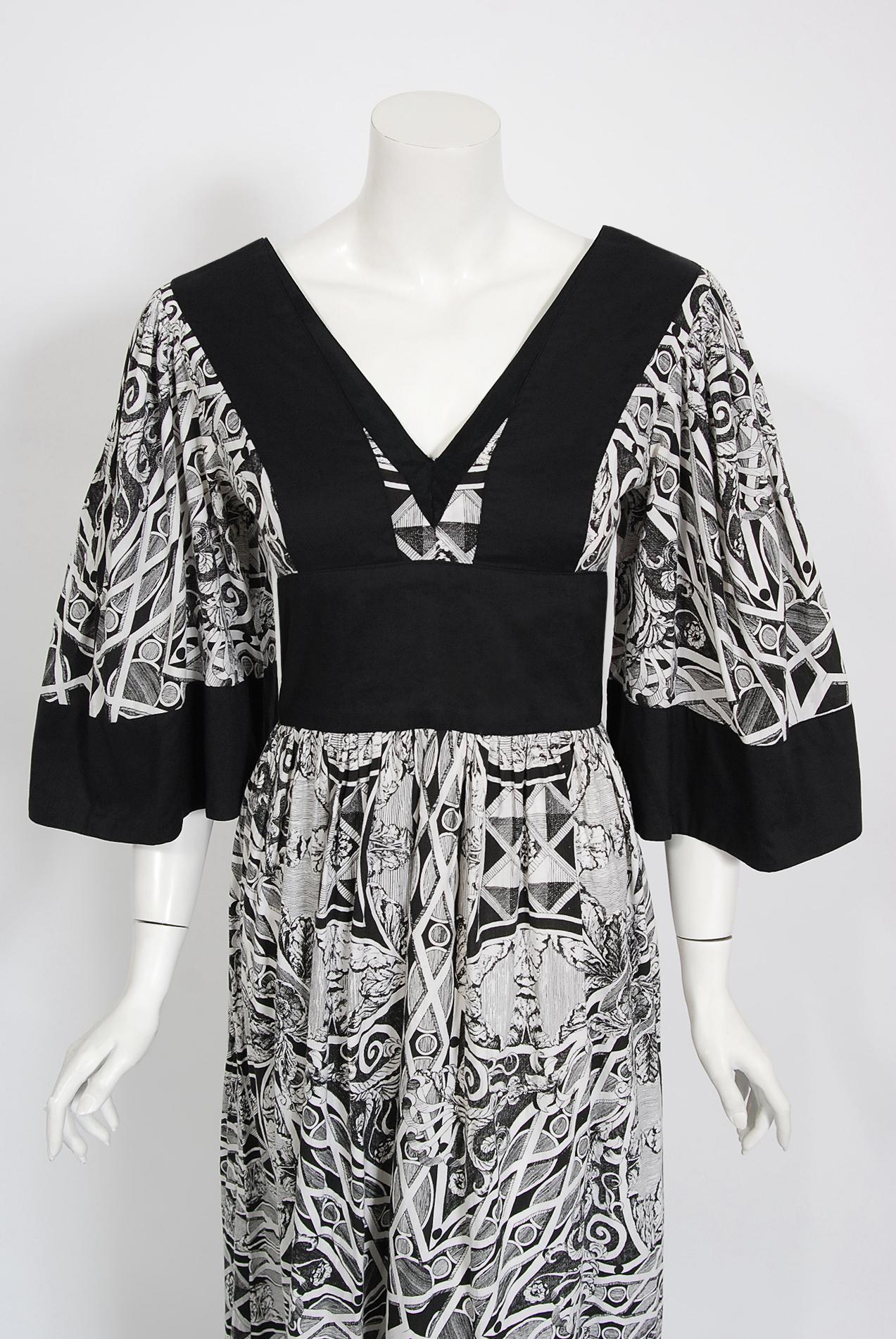 Gorgeous early-1970's Thea Porter designer couture dress fashioned in magical black and white kaleidoscope floral cotton print. I love the dramatic bell-sleeves and bold block coloring. The silhouette is a flattering nipped-waist full length design.