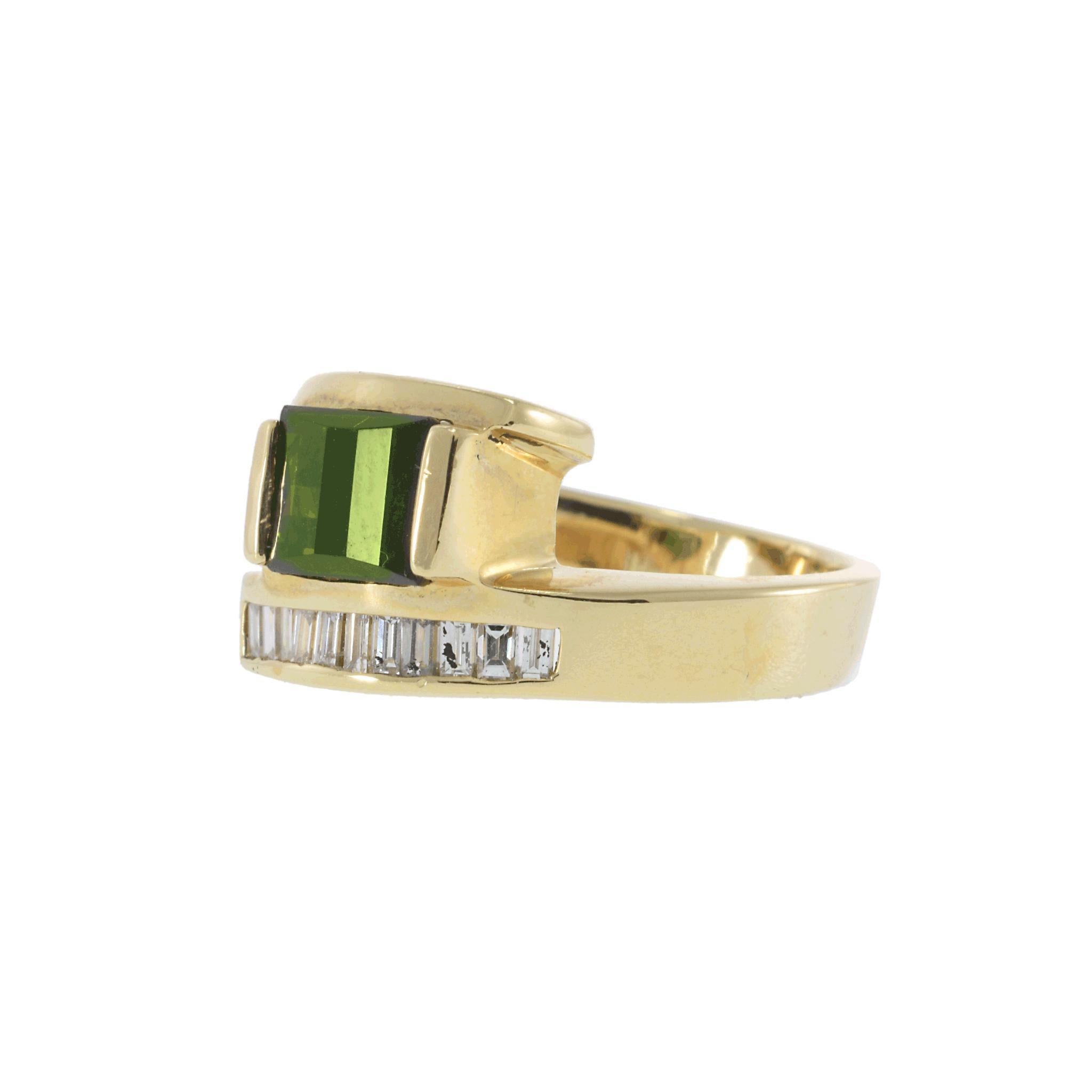 A striking vintage 1970s split ring, featuring a beautifully curved faceted-cut green tourmaline set in a bold, artistic design. Accentuating the tourmaline’s deep green hue are 0.40CT-TW of G-VS baguette-cut diamonds, adding brilliance and