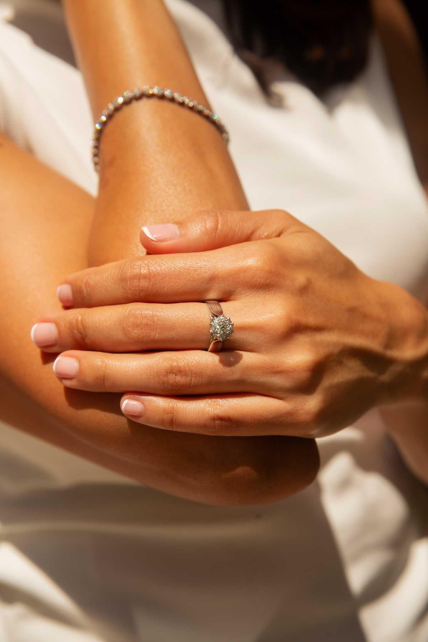 A dazzling diamond, surrounded by a halo of shimmering stones, our Carly Ring is a masterpiece of exquisite craftsmanship. Set in 18 carat white gold, her central gem, a brilliant star of light, is encircled by a constellation of smaller diamonds,