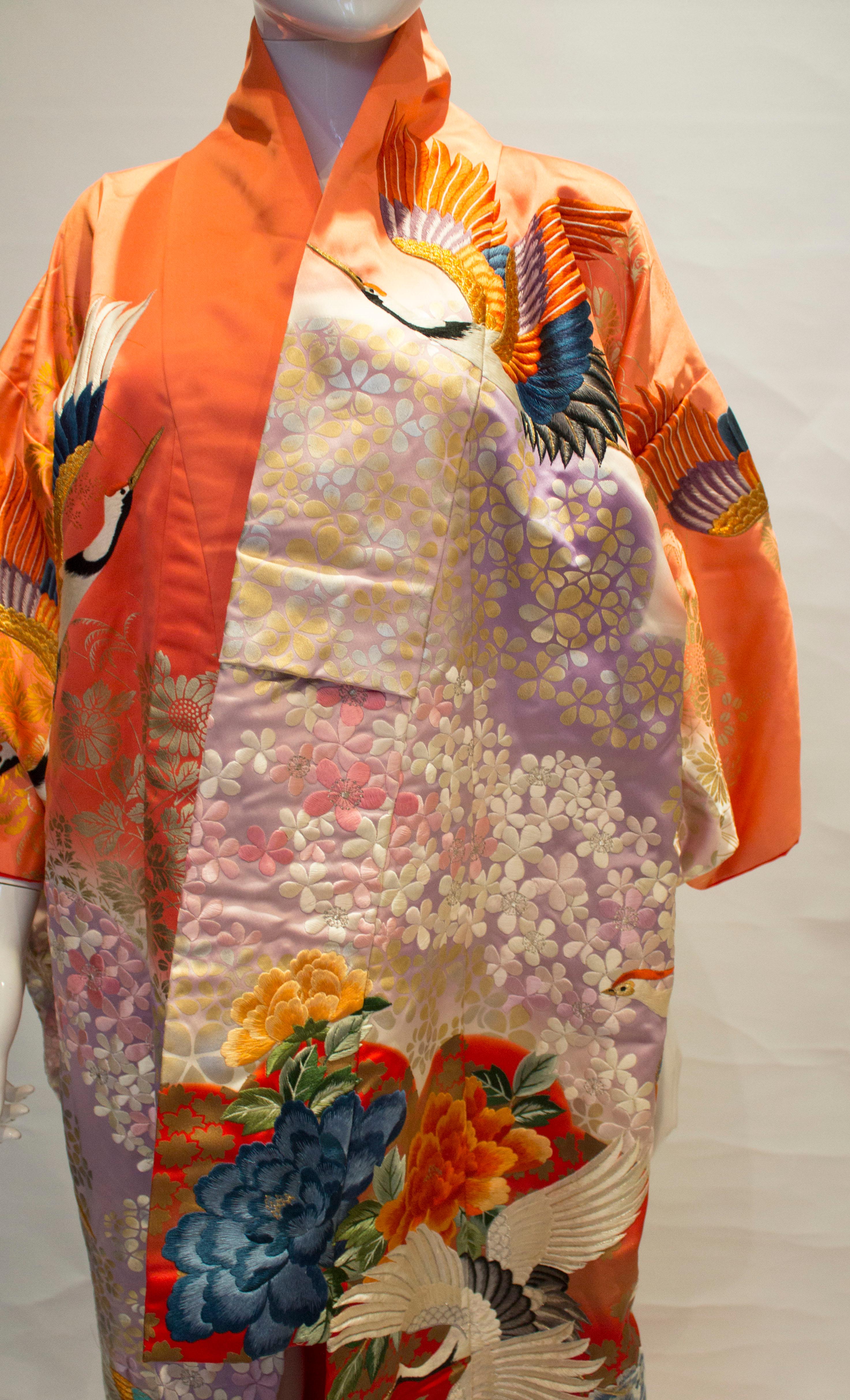 A stunning wedding kimono from the 1970s. The kimono has wonderful embroidery with flower and crane detail in shades of pink, red and orange, It is lined in red.

Measurements bust up to 51'', length 72''