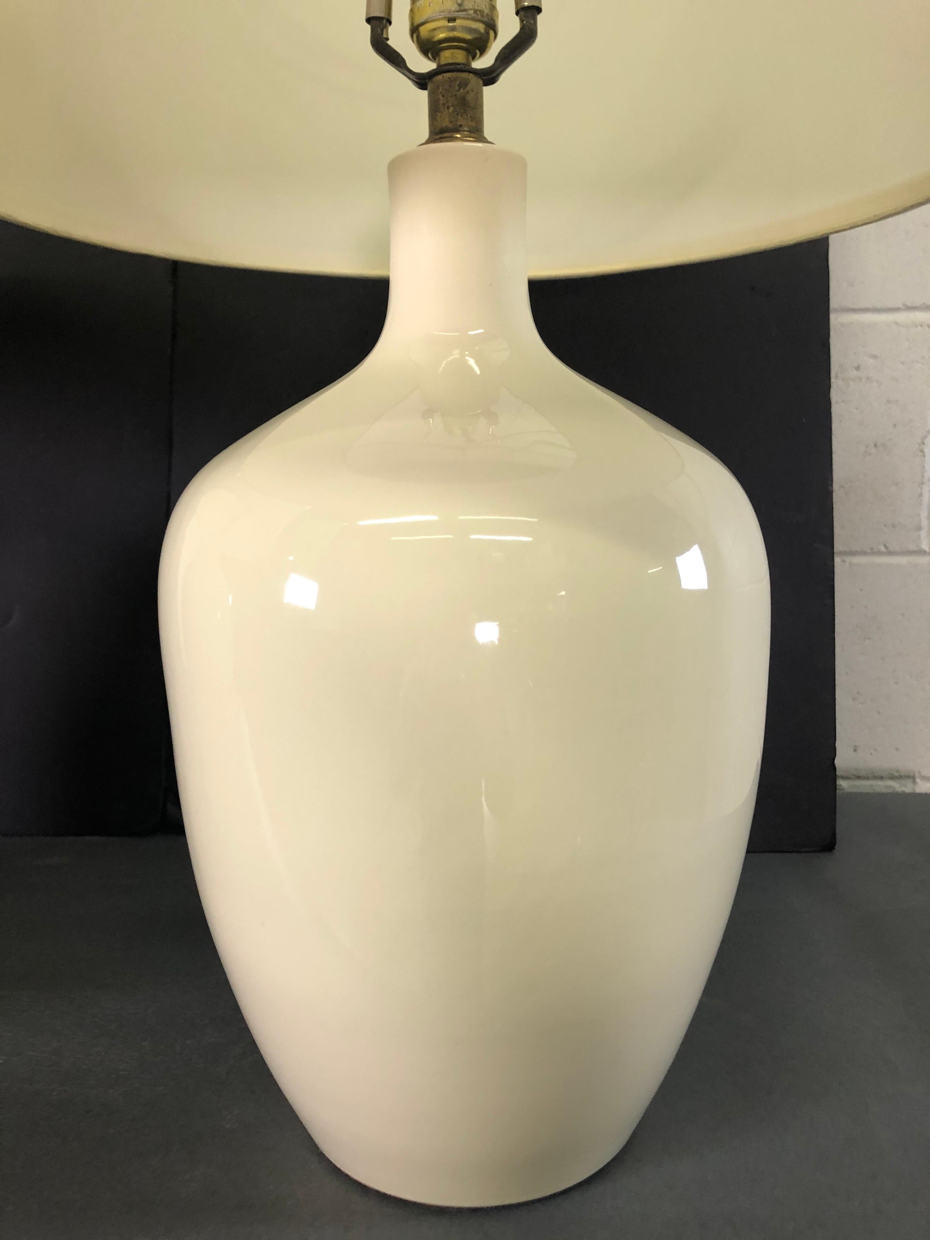 Vintage 1970s white ceramic barrel lamps by Haeger. Wired for the US and in working condition. Measures: Socket: 20” H. Harp: 4” W x 7” H. Marked. Shades not included.