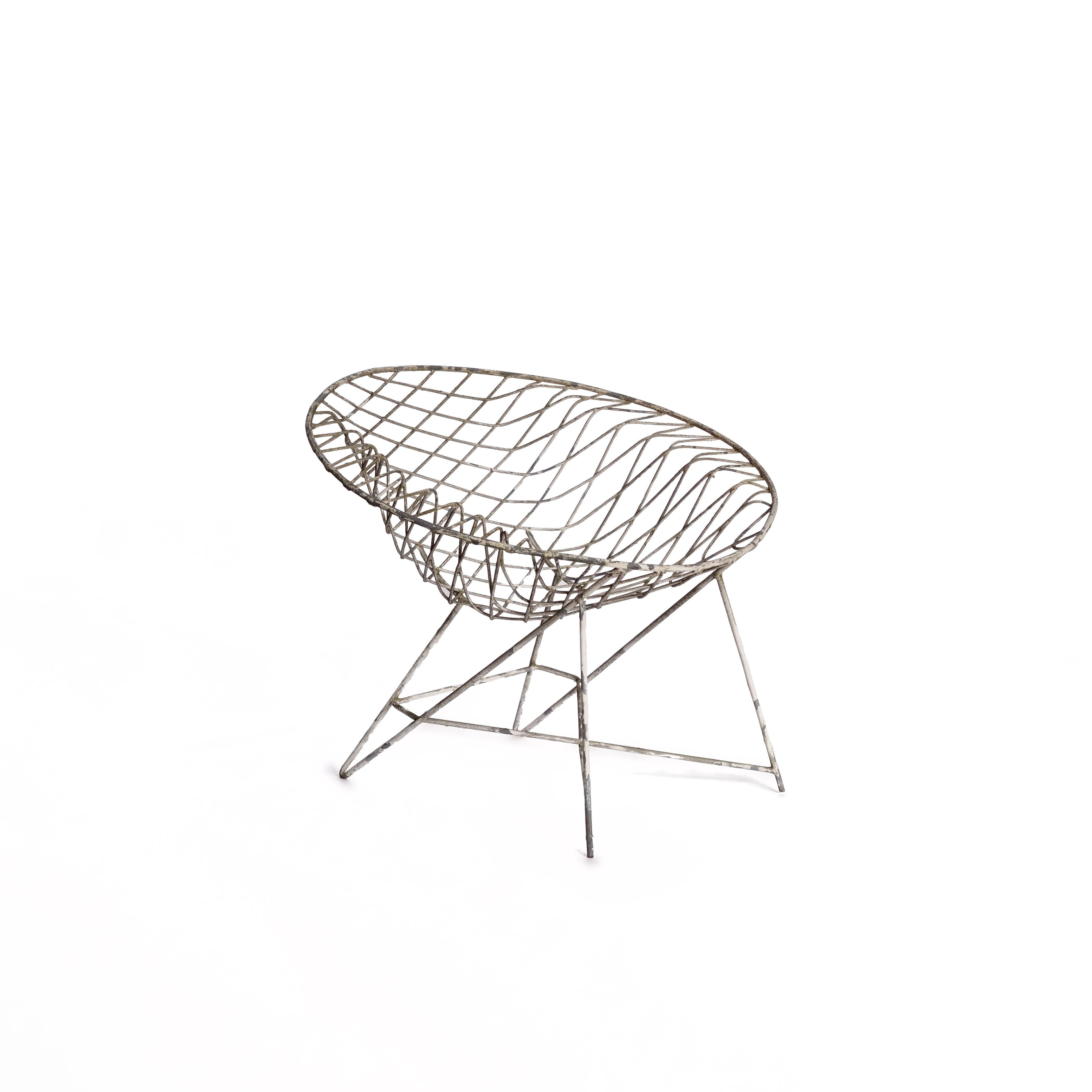 This striking wire arm chair from the 1970s is a true statement piece. Crafted with a sculptural, open-frame design, the chair combines minimalism with character. Over the decades, its metal surface has developed a beautiful natural patina, adding