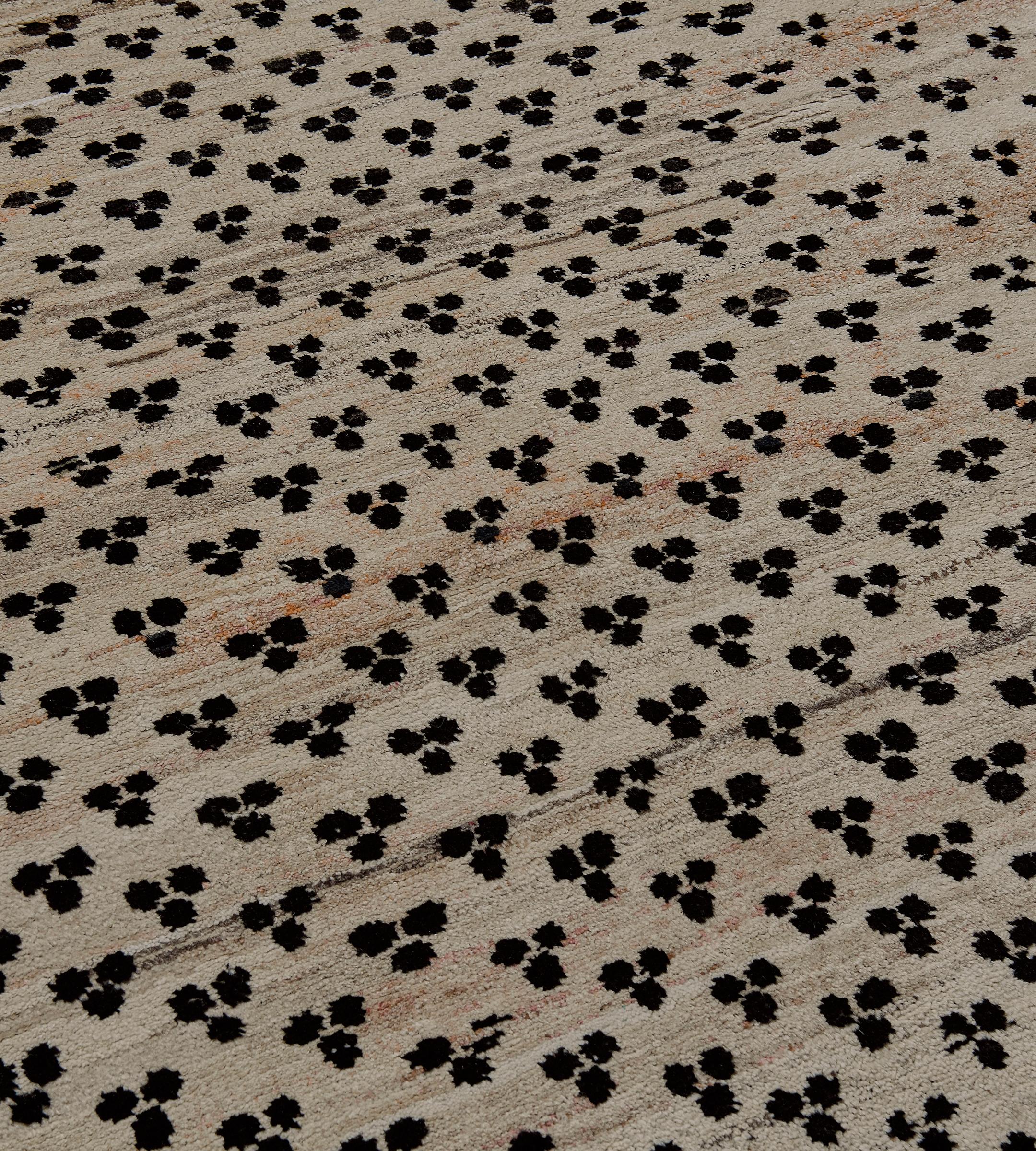 This dynamic vintage rug from the late 20th century is hand-knotted in Turkey from the finest wool. Featuring a distinct tiger eye design on a muted beige field surrounded by a diamond pattern motif, the geometric pattern and earthy red borders add