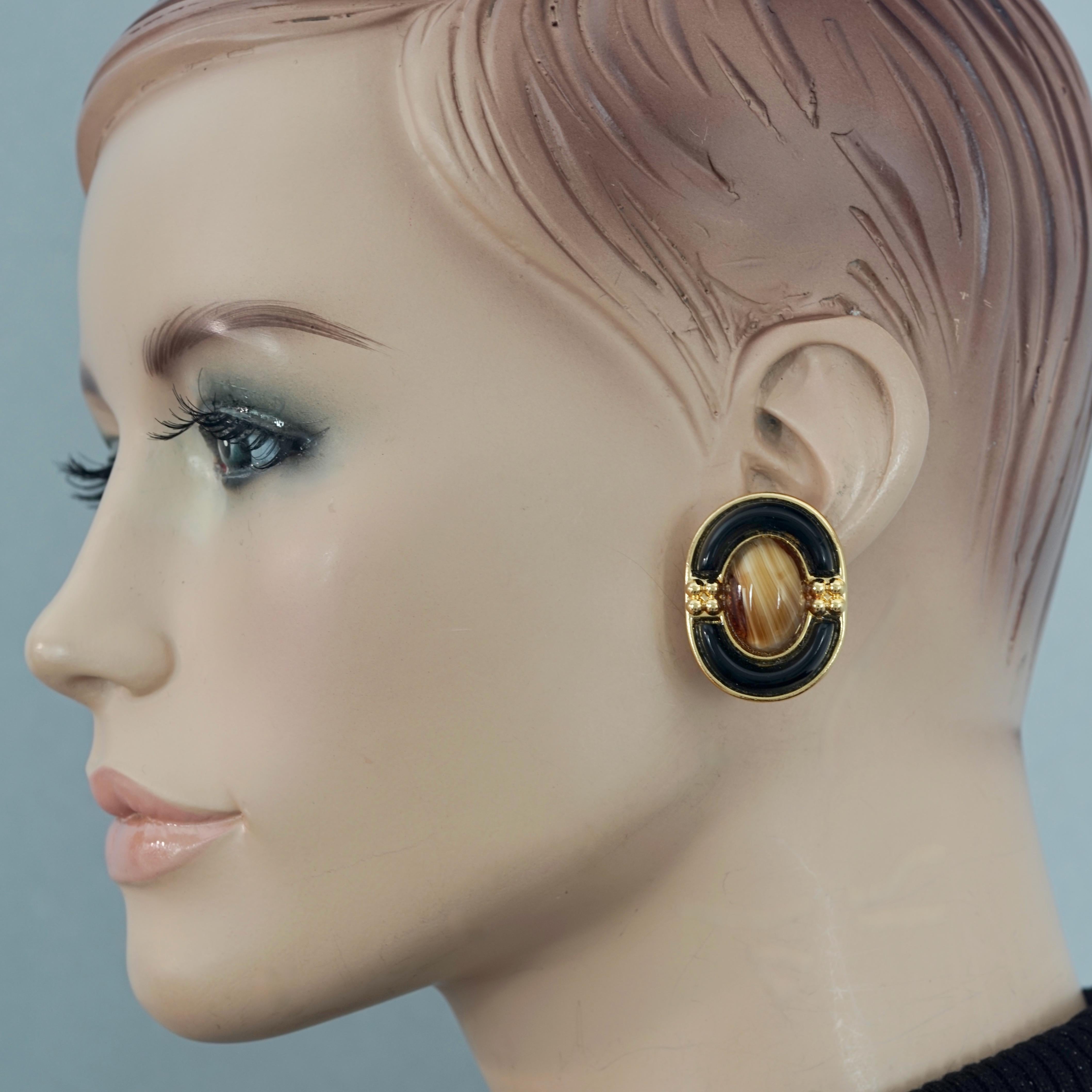 Vintage 1971 CHRISTIAN DIOR Tiger Eye Oval Glass Cabochon Earrings

Measurements:
Height: 1.34 inches (3.4 cm)
Width: 1.02 inches (2.6 cm)
Weight per Earring: 14 grams

Features:
- 100% Authentic CHRISTIAN DIOR.
- Glass tiger eye cabochon surrounded